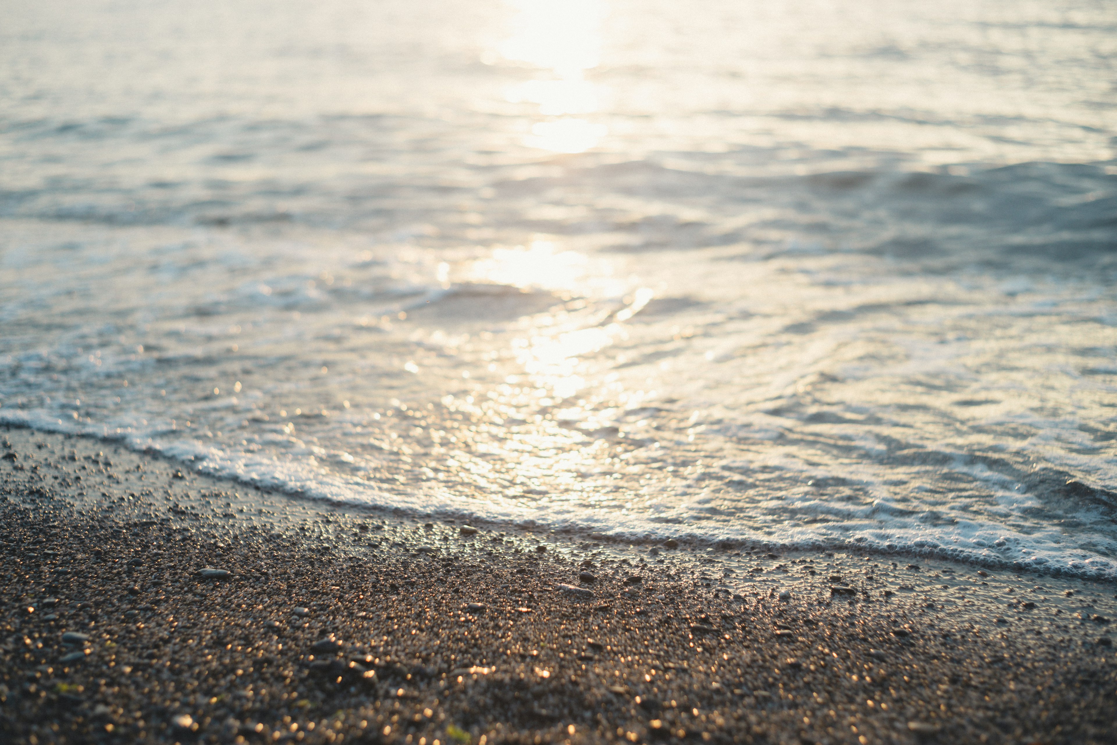 Sanfte Wellen des Ozeans, die an einen Sandstrand schlagen