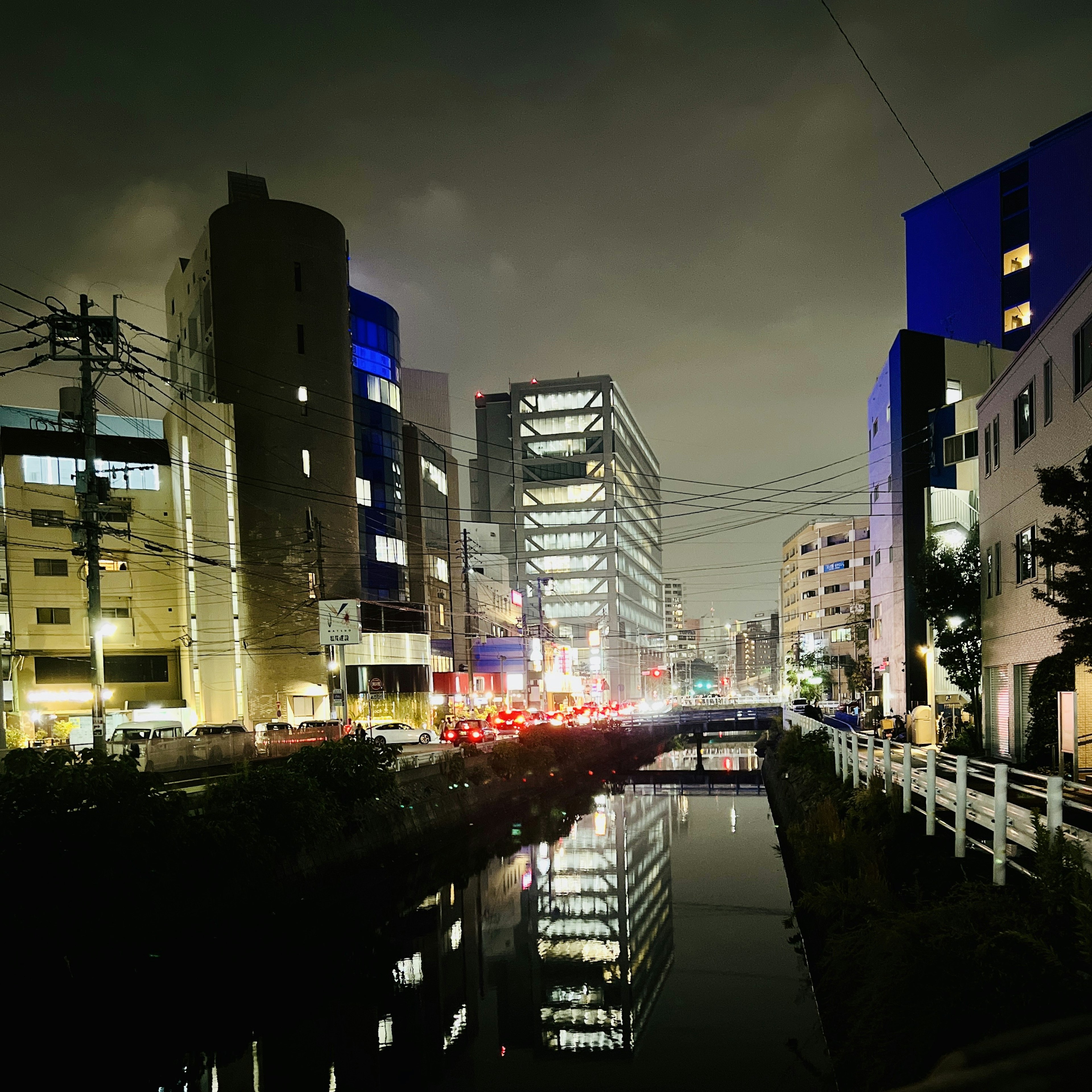 Paesaggio urbano notturno con grattacieli che si riflettono nell'acqua