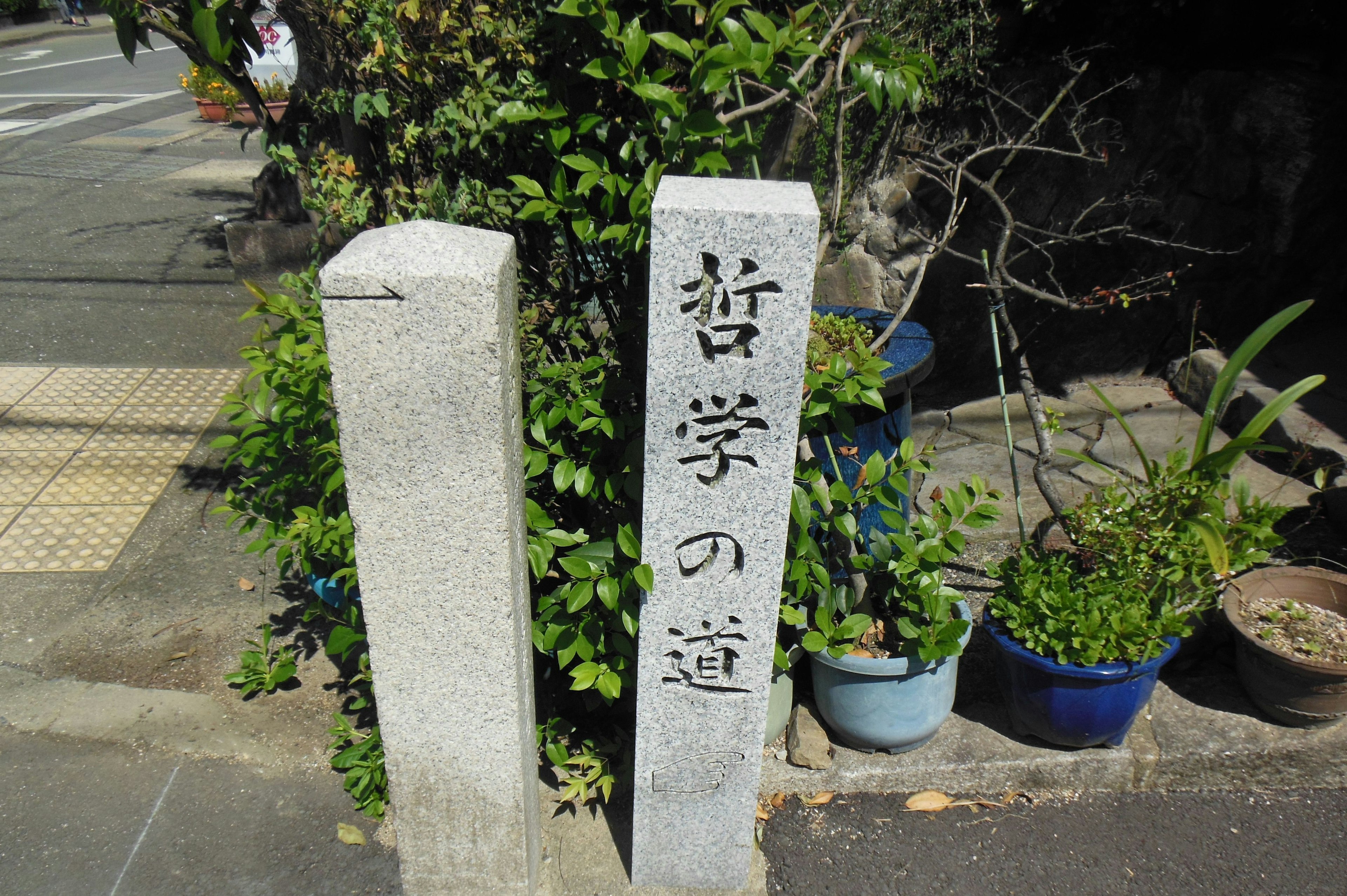 Stone sign engraved with 'Philosopher's Path' in a lush green setting