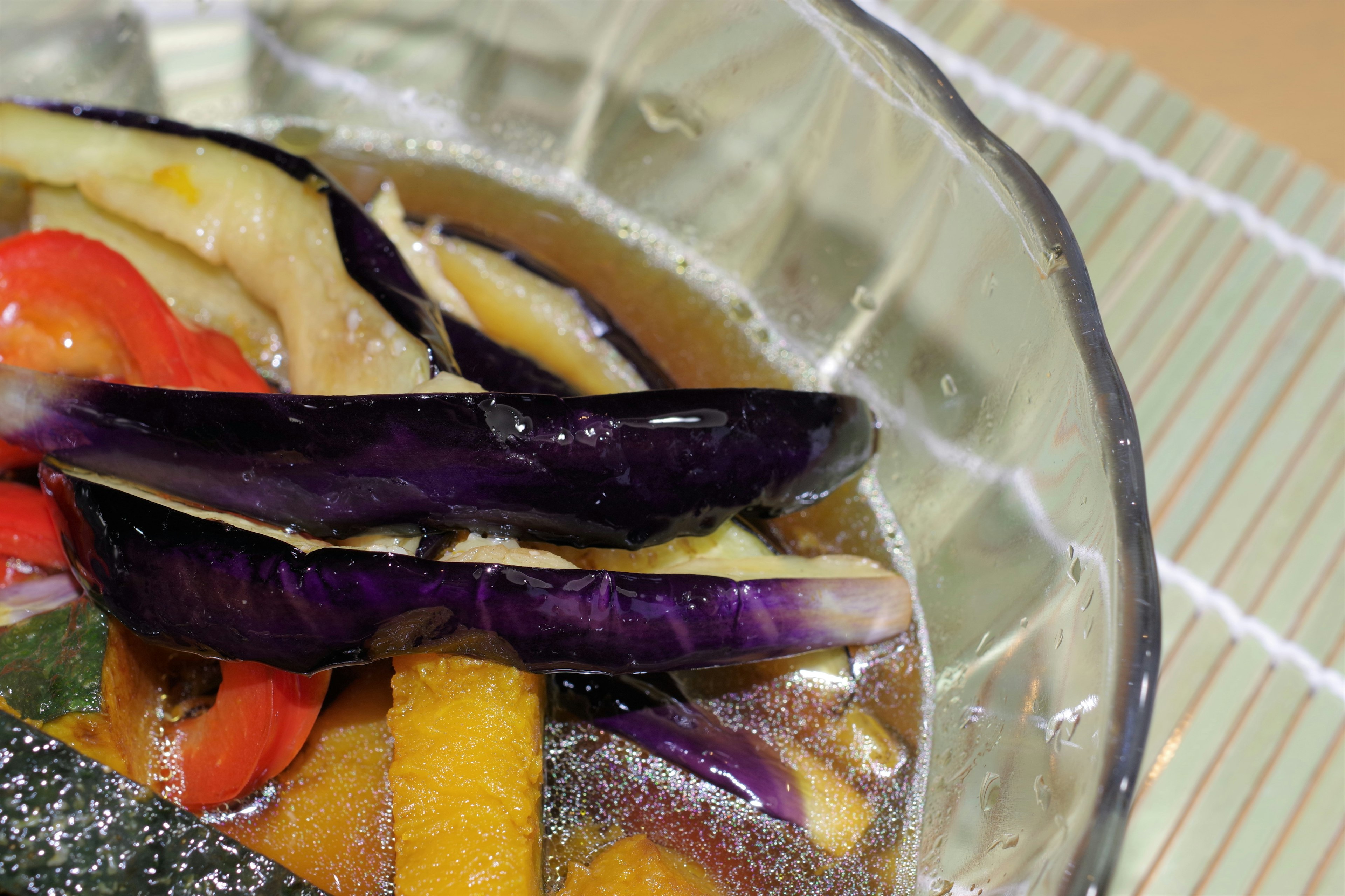 Aubergine et poivron rouge mijotés dans un plat en verre