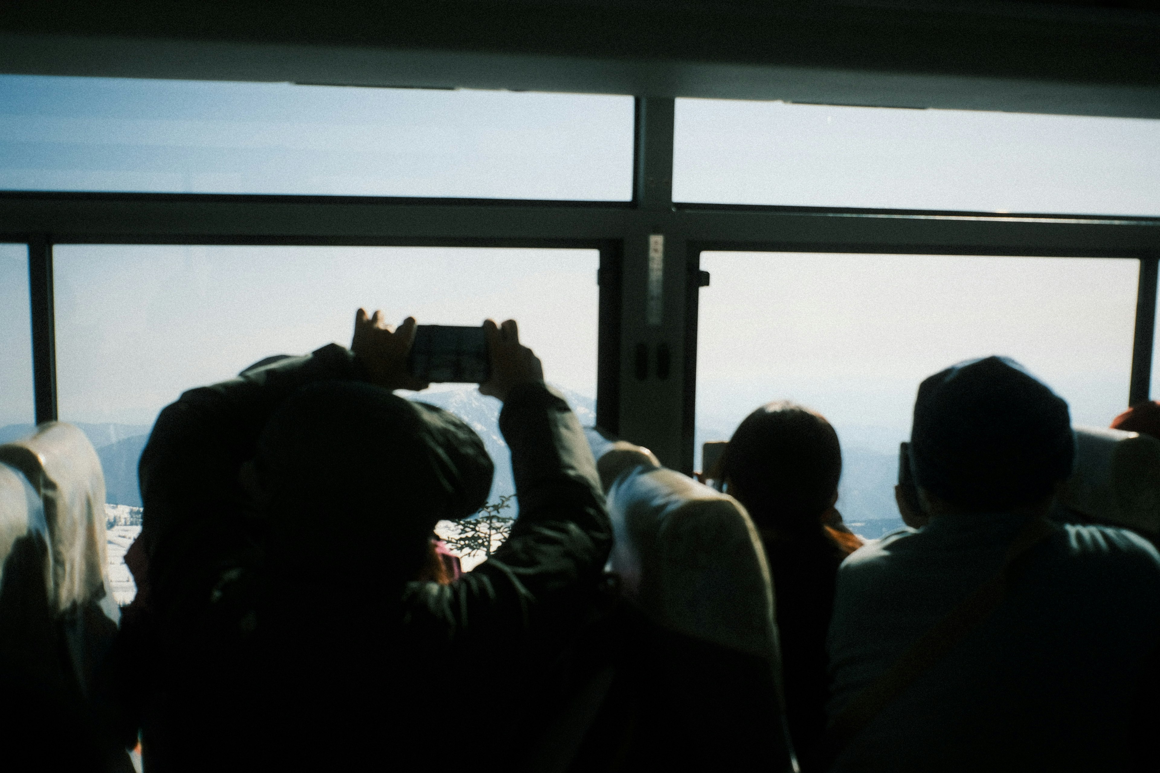 Silhouetten von Touristen, die aus dem Fenster schauen