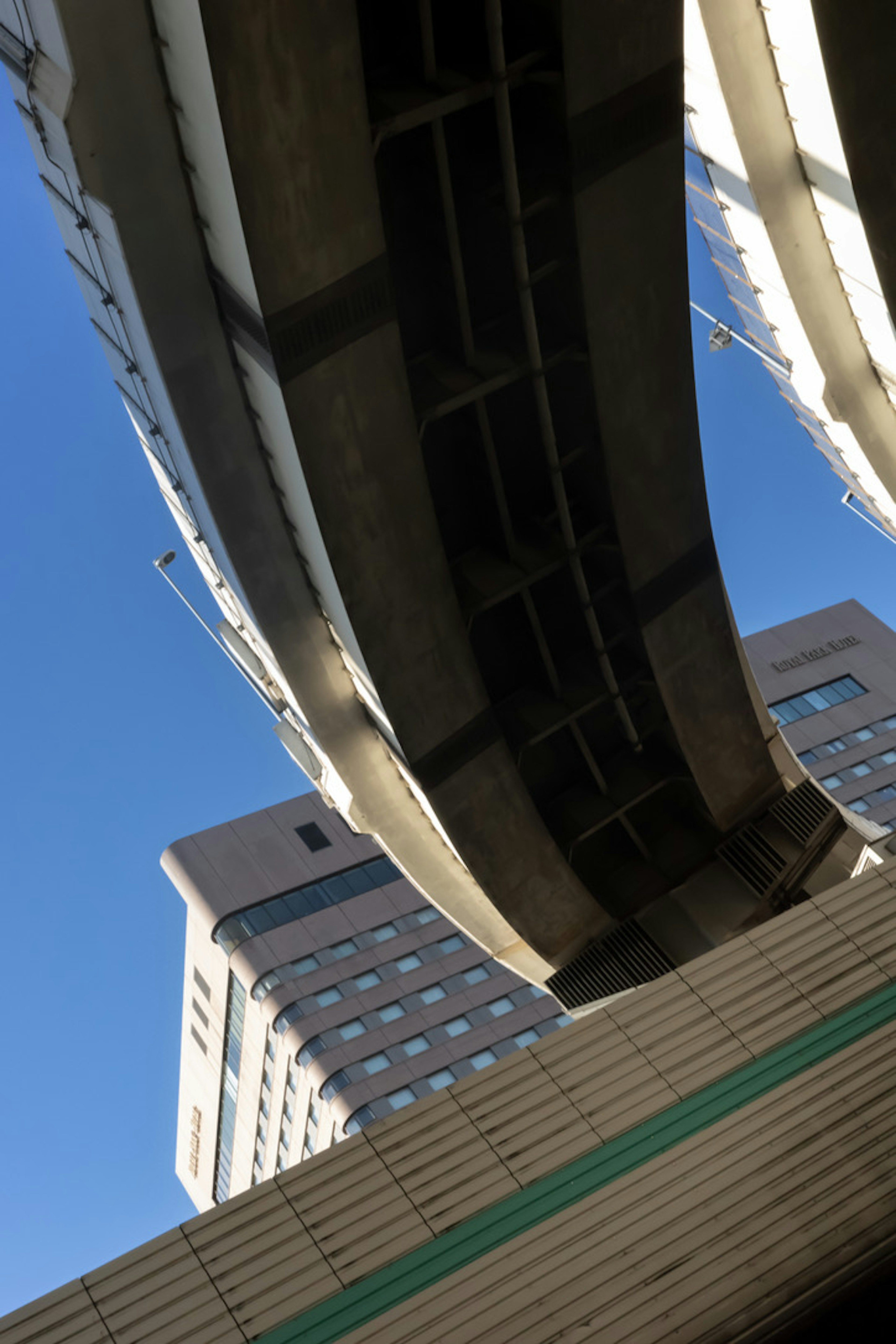 Overpass structure with buildings under a clear blue sky