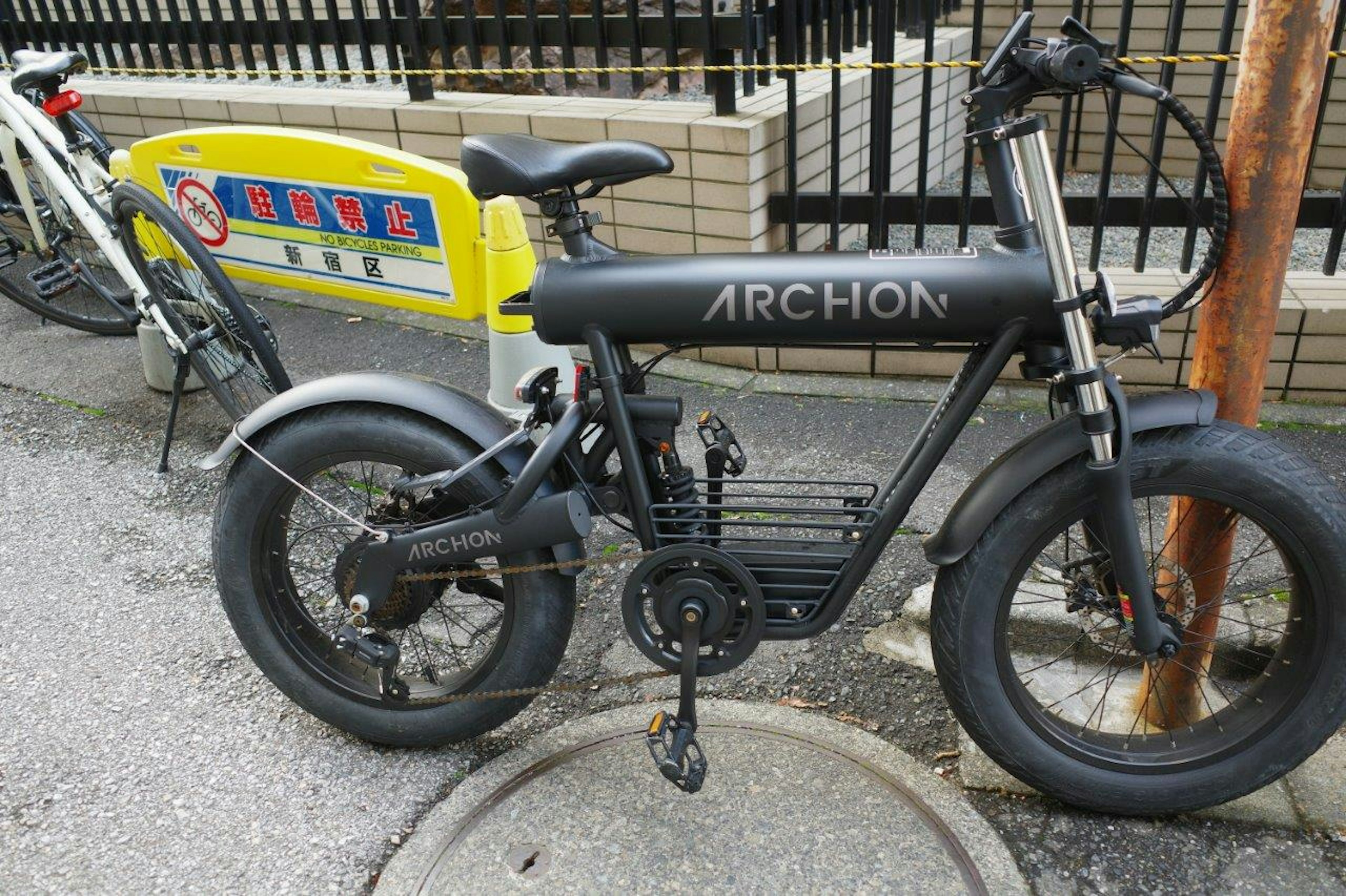 Vélo électrique ARCHON noir avec de gros pneus garé dans la rue