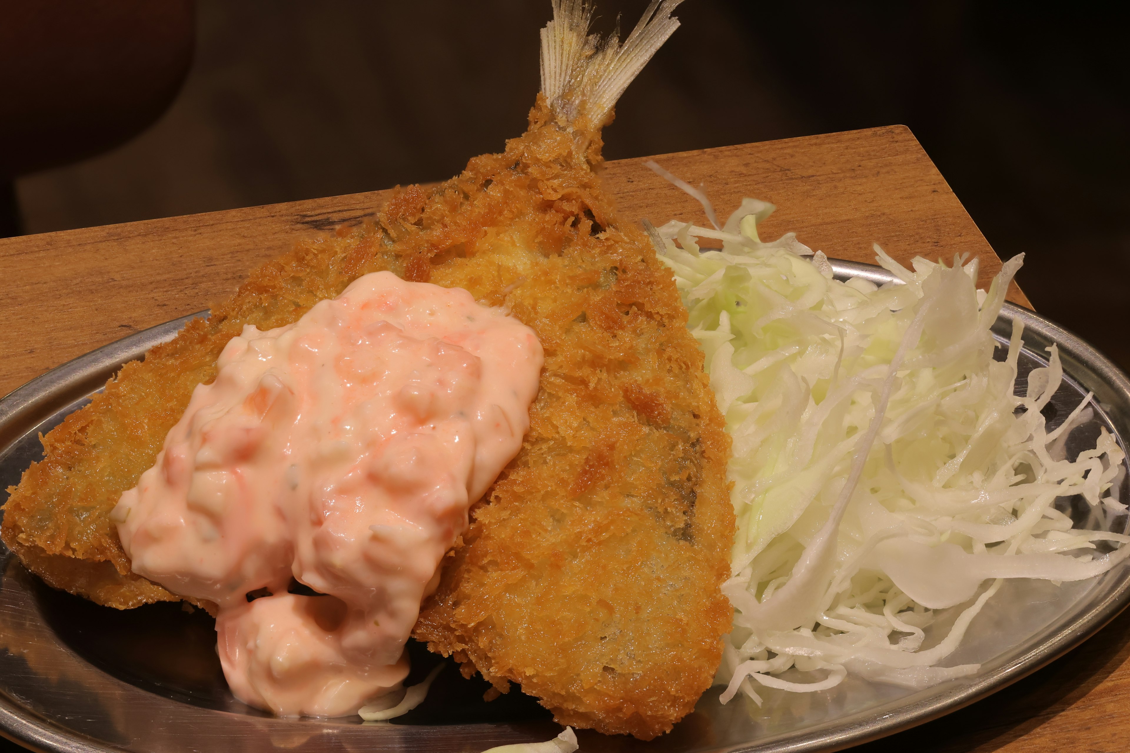 Poisson frit avec sauce rose servi sur une assiette avec du chou râpé