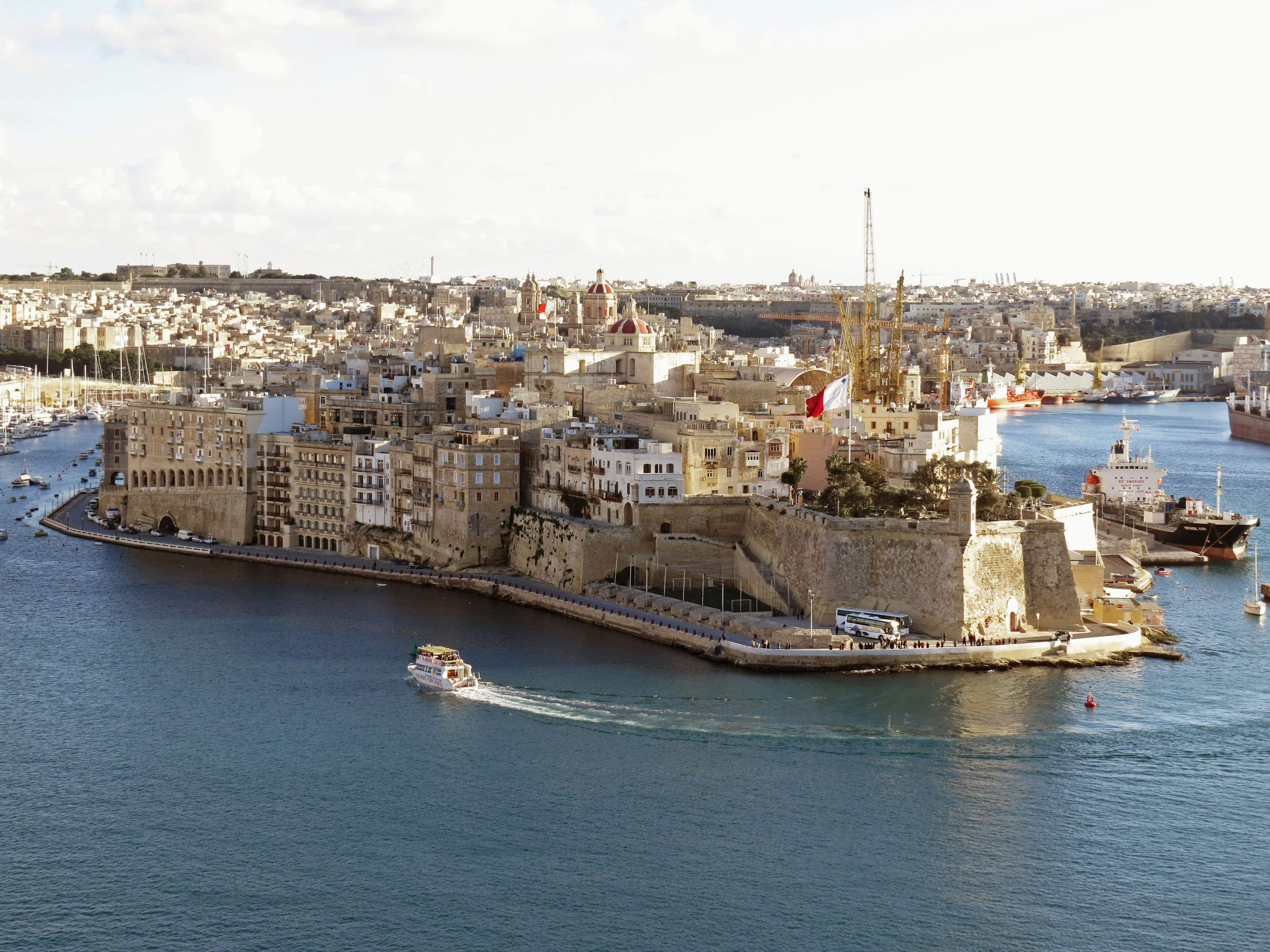 Eine malerische Aussicht auf ein historisches Gebäude in Valletta umgeben von Wasser und Booten