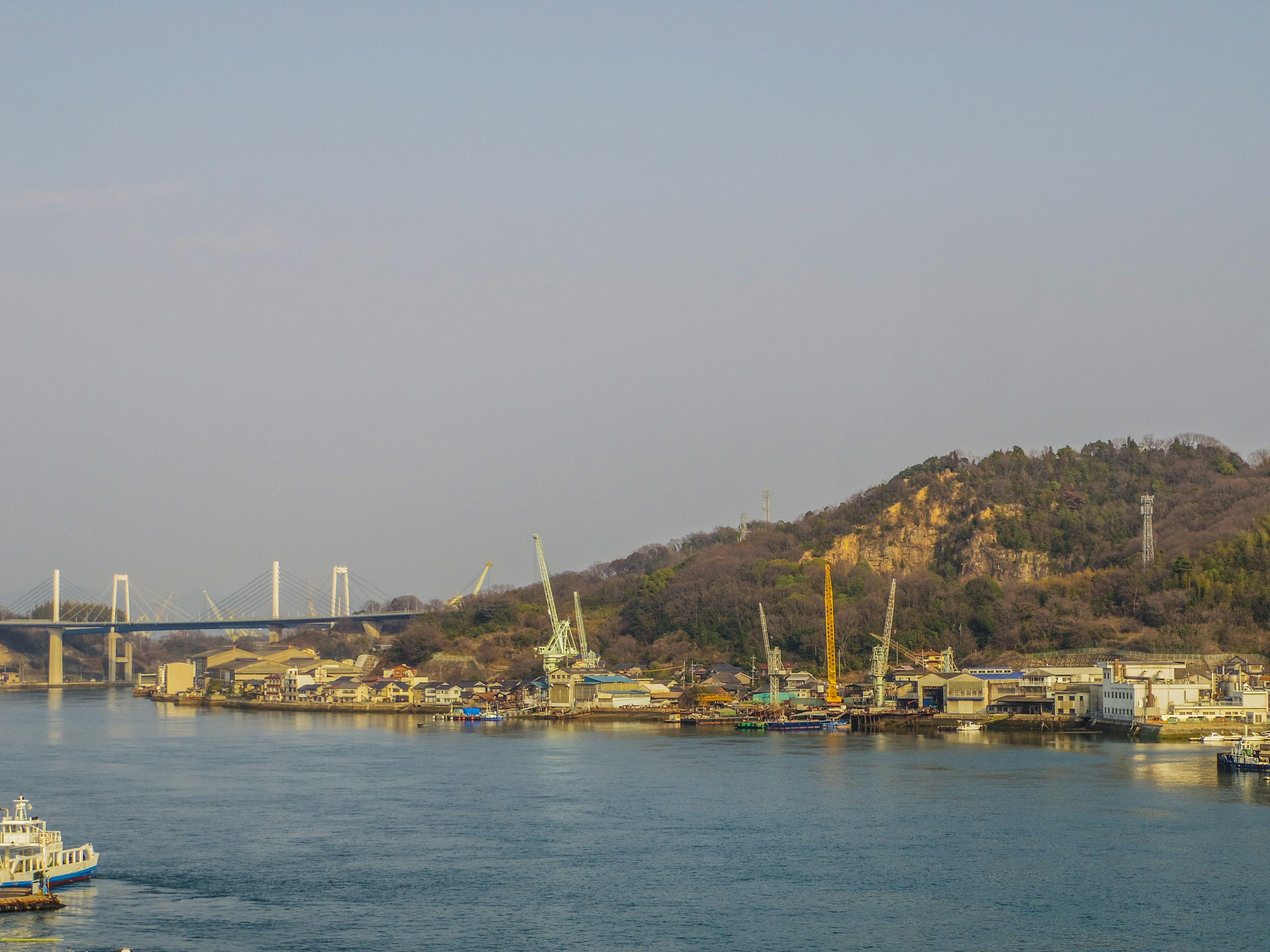 Vue d'une rivière avec des grues et des bateaux sur la rive