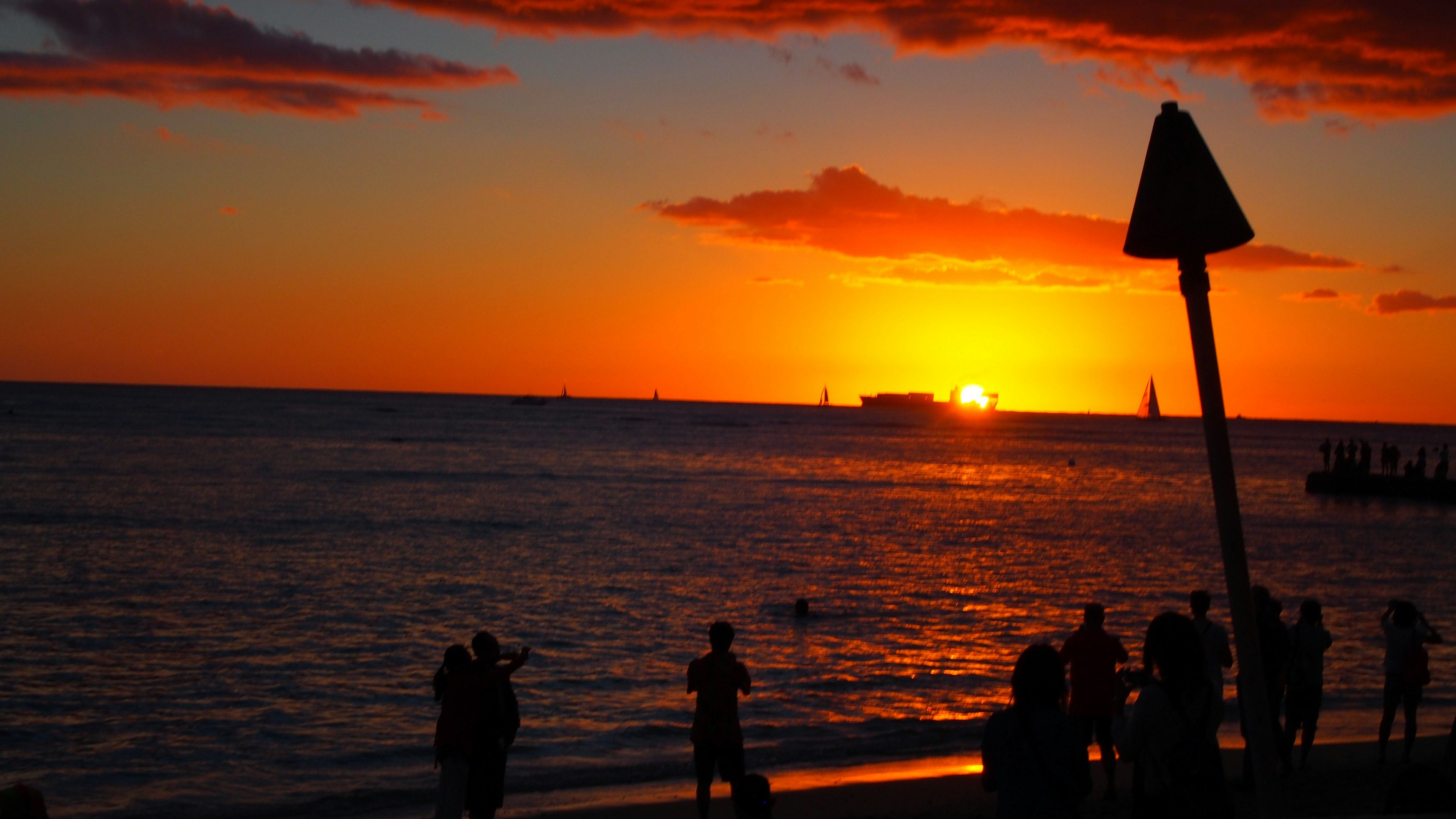 Beautiful sunset over the ocean with silhouetted people on the beach