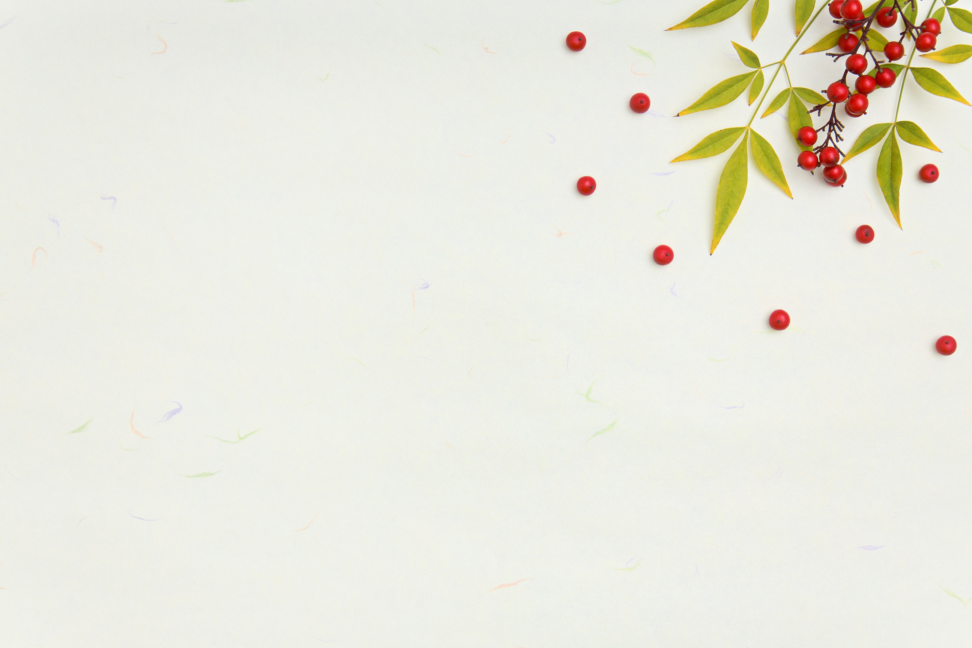 Simple design featuring red berries and green leaves on a light background