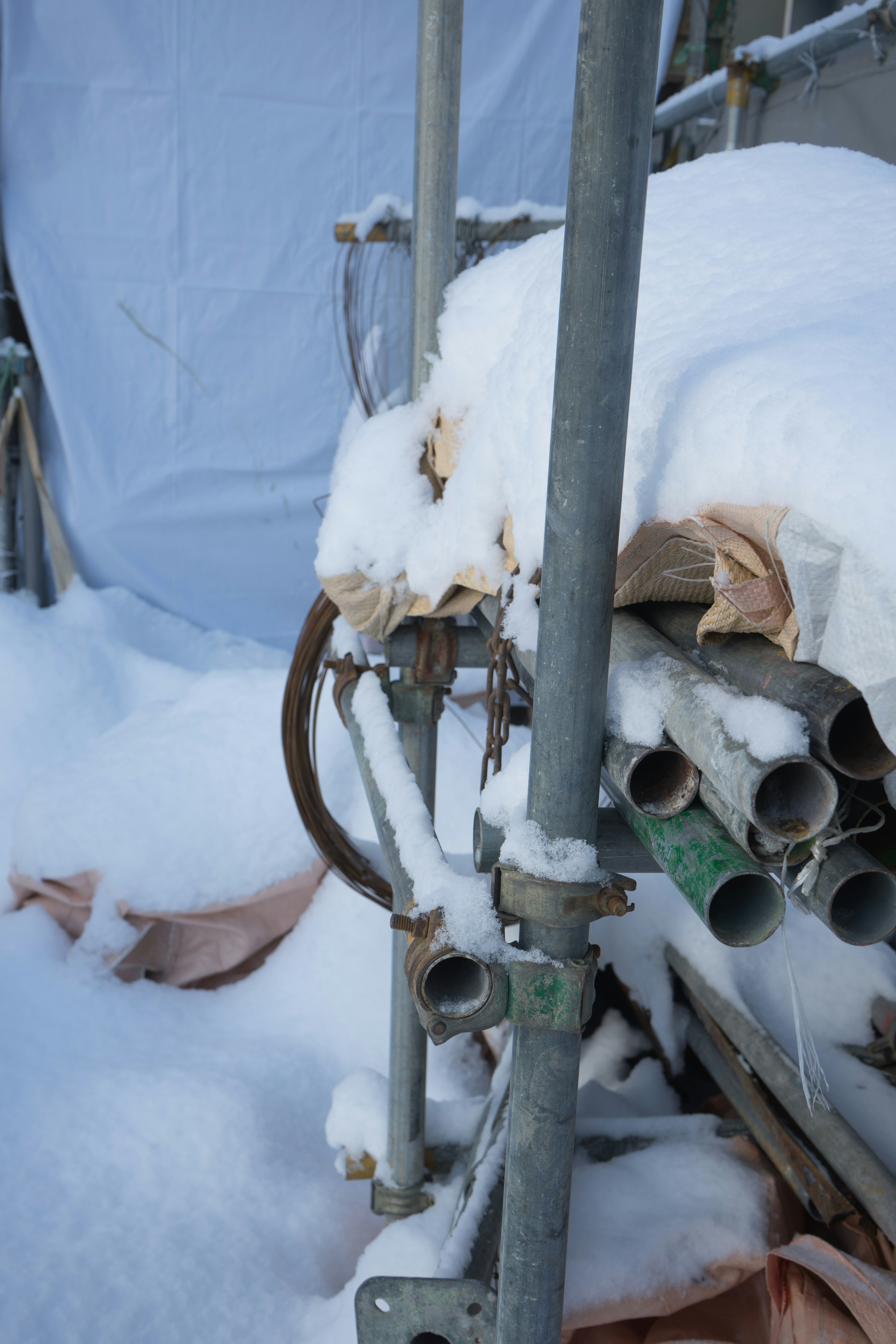 Scène hivernale avec des tuyaux et un échafaudage recouverts de neige