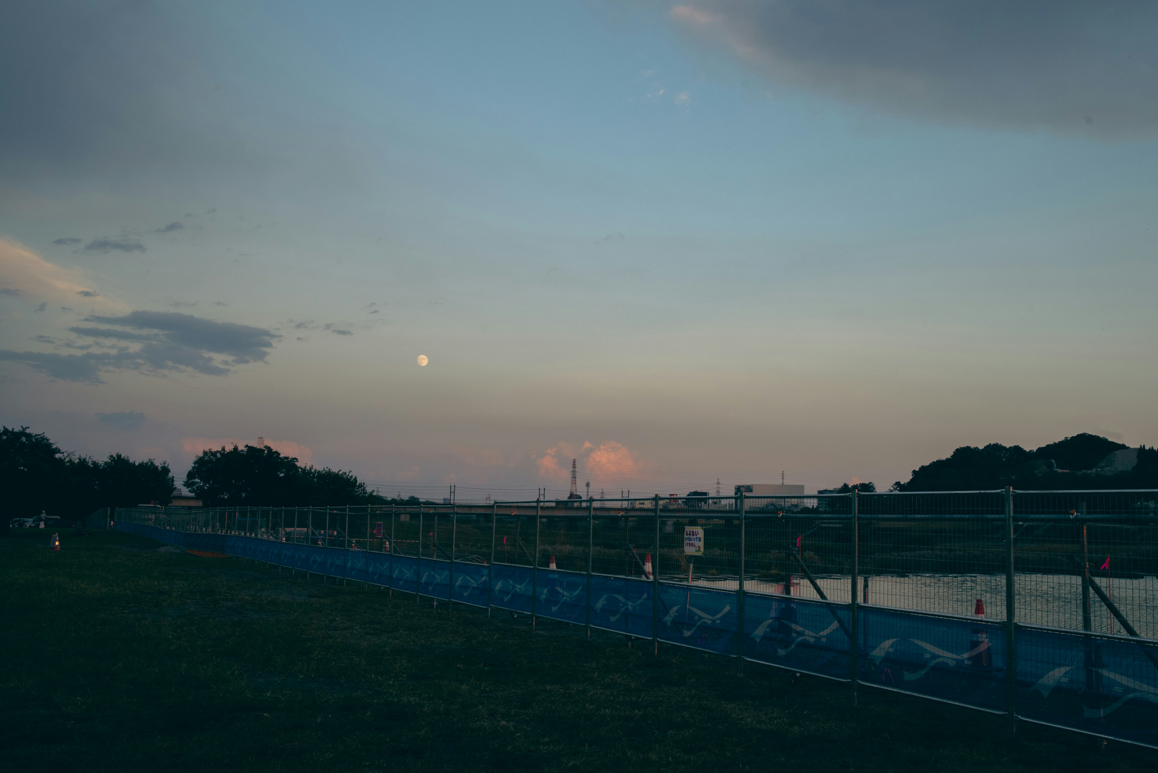 夕暮れの空と水辺の景色に沿ったフェンス