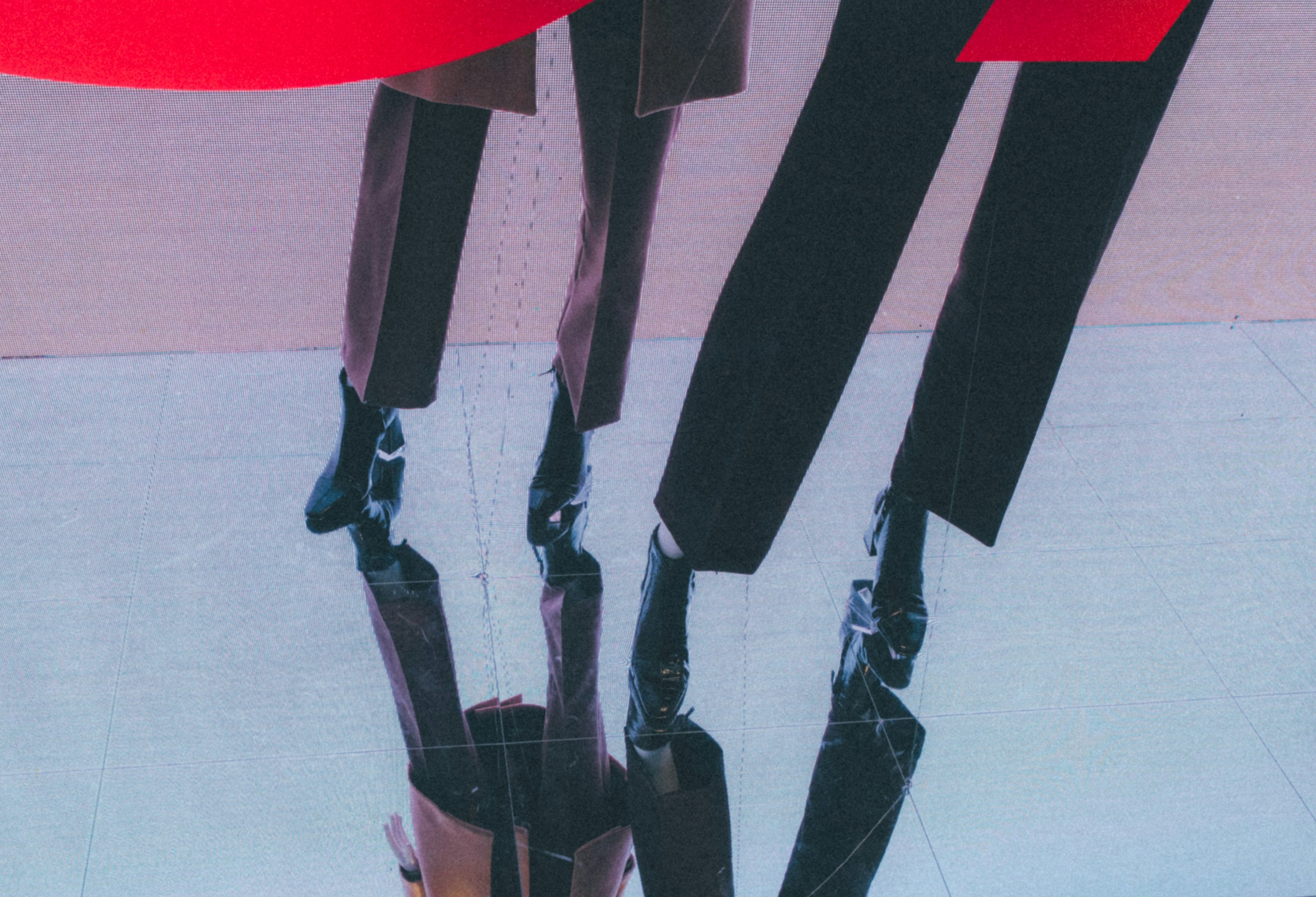 Display of suit legs and shoes against a red background