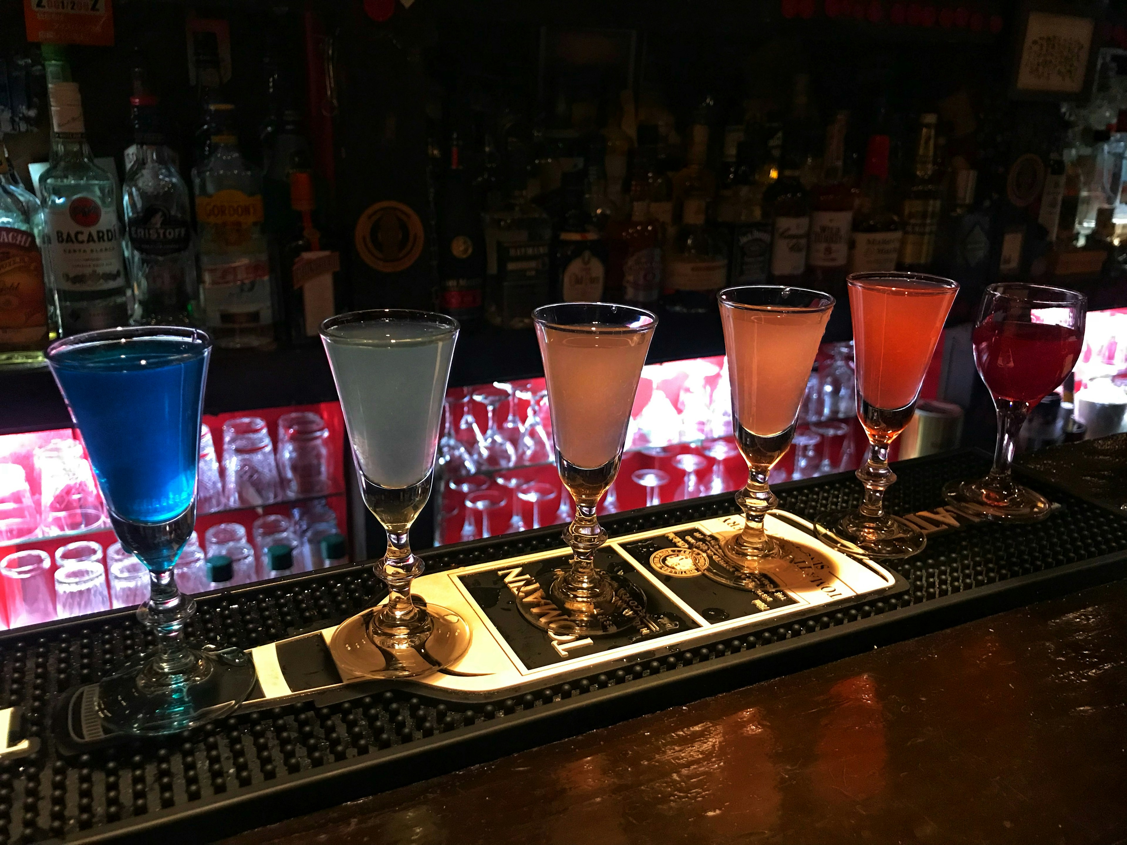 Colorful cocktails lined up on a bar counter