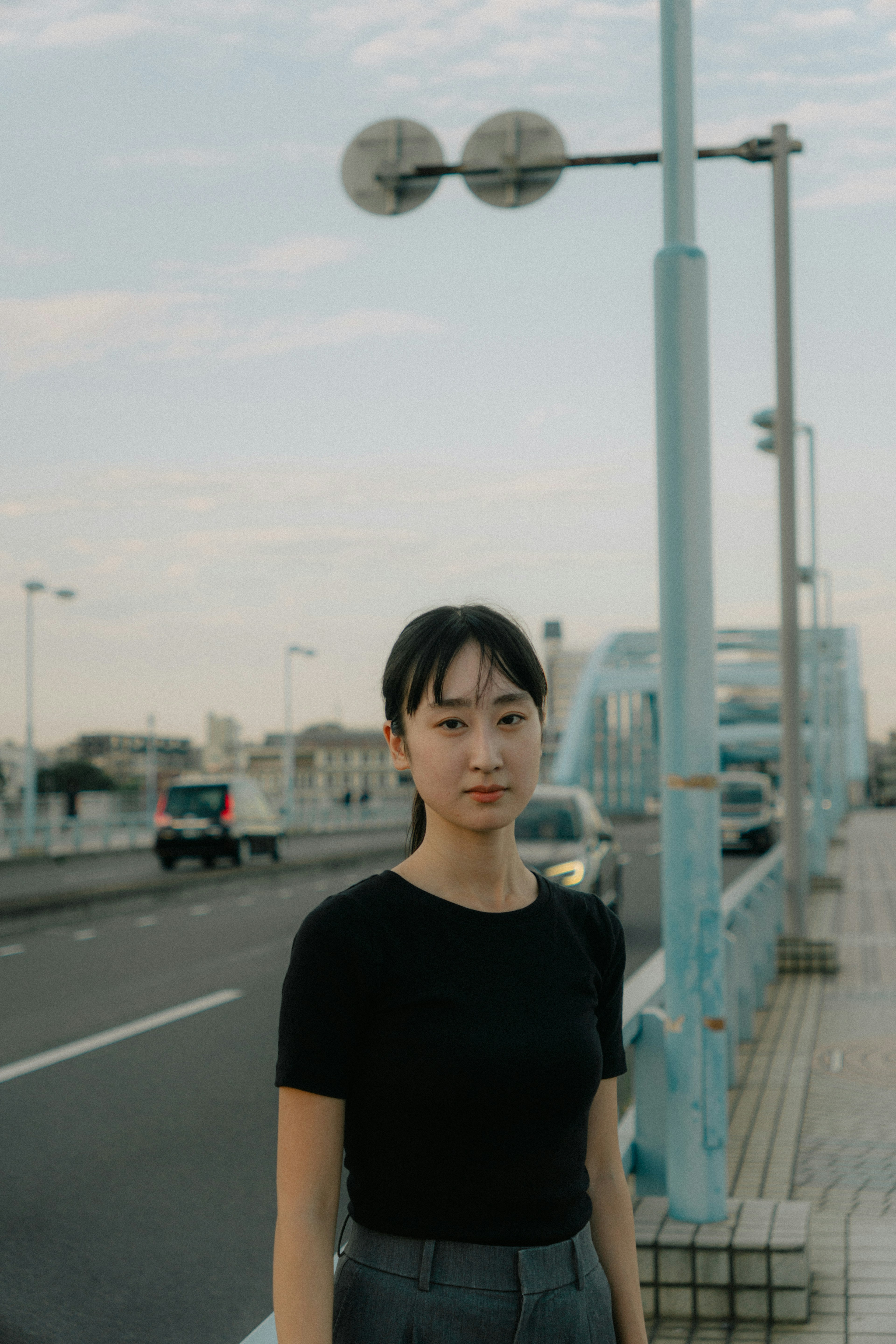 Portrait d'une femme se tenant près d'un pont portant un t-shirt noir