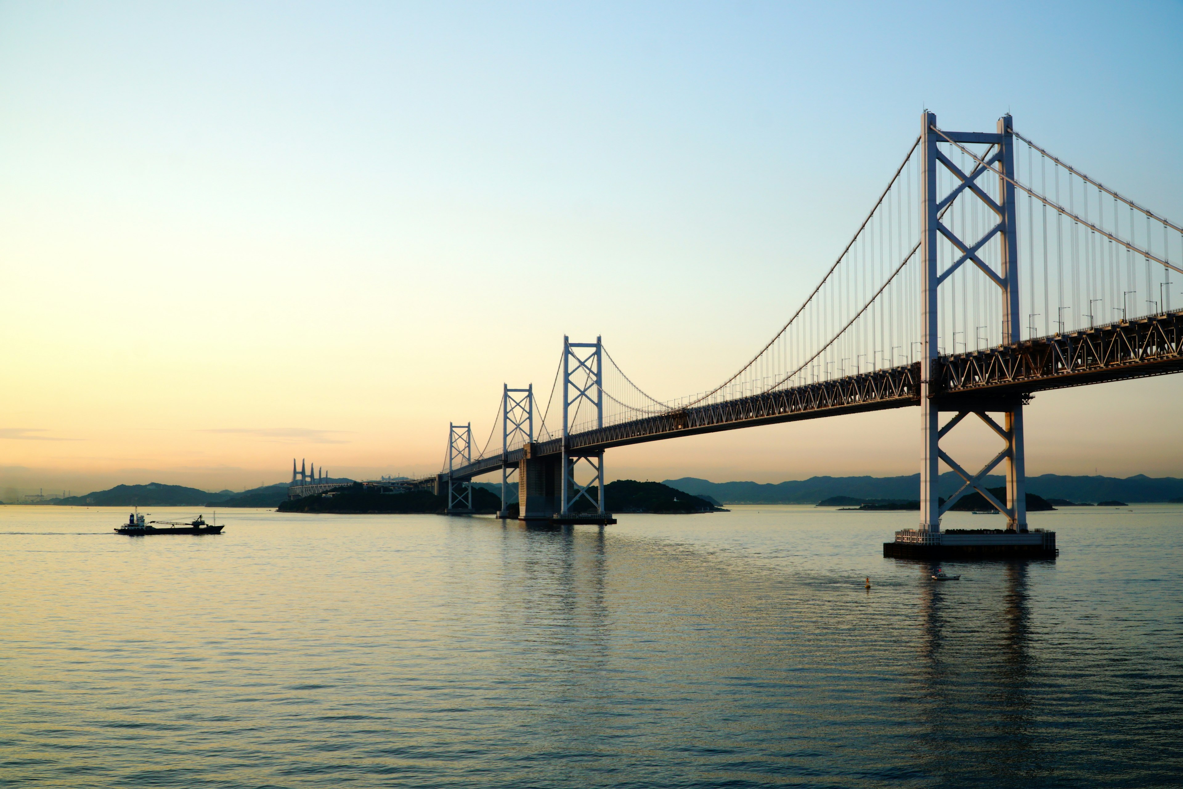 Magnifique pont suspendu au-dessus des eaux calmes au coucher du soleil