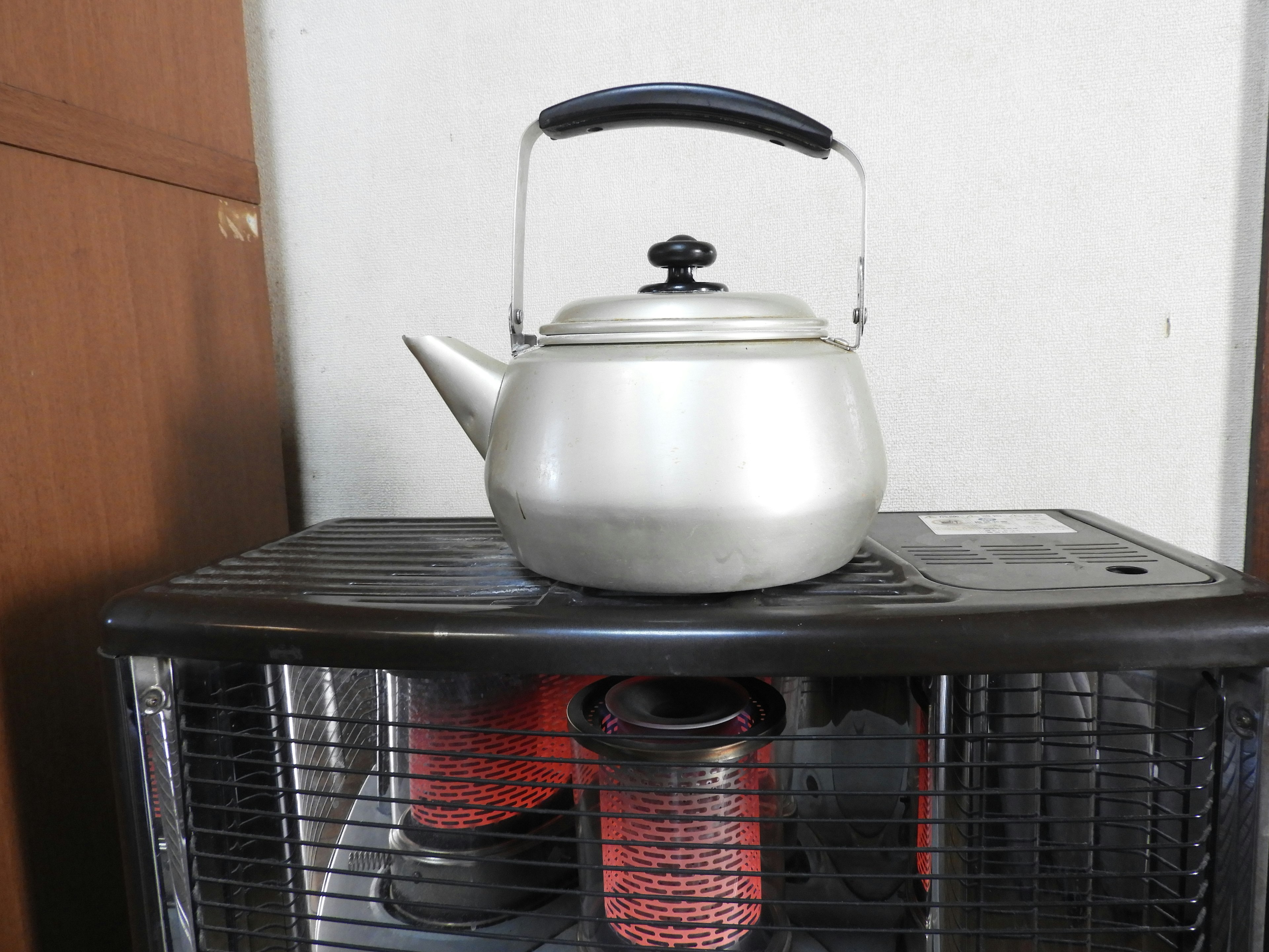 A metallic kettle placed on top of a heater