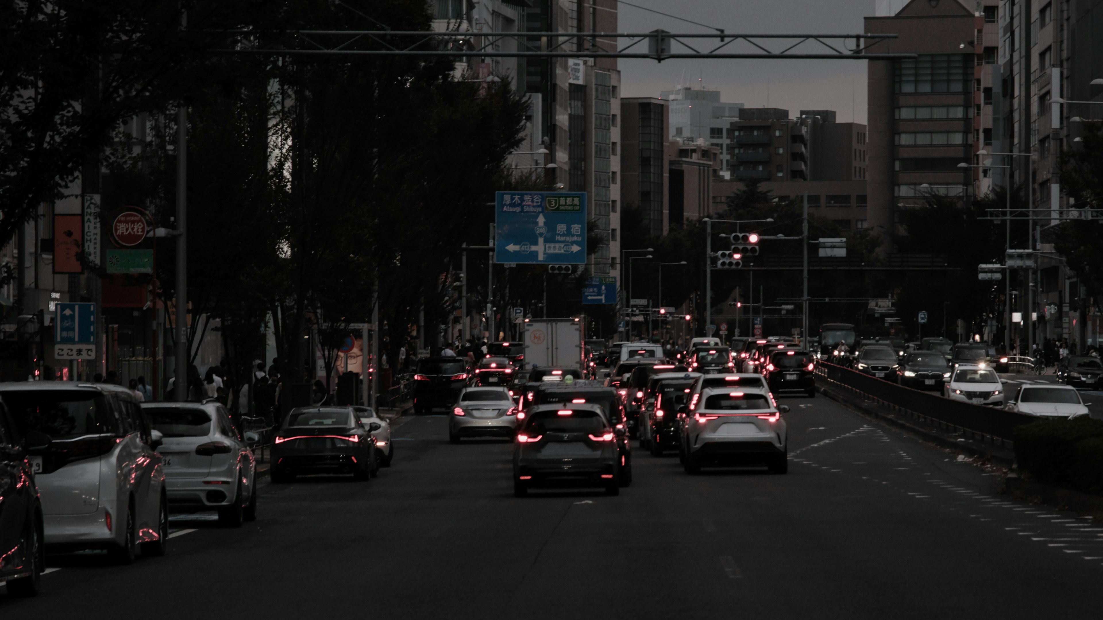 Dark city street with parked cars and buildings