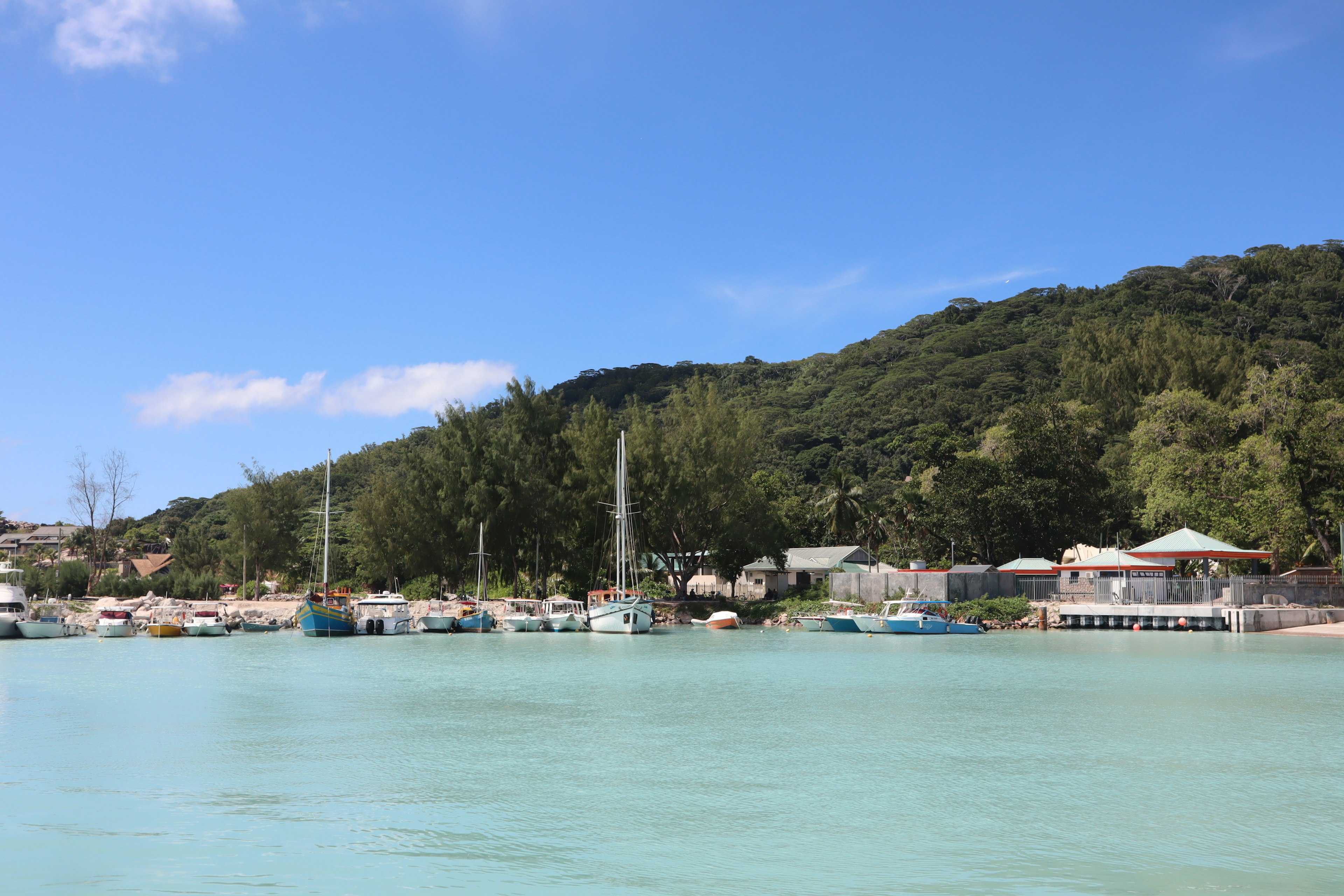 Scenic view of boats on turquoise water with green hills in the background