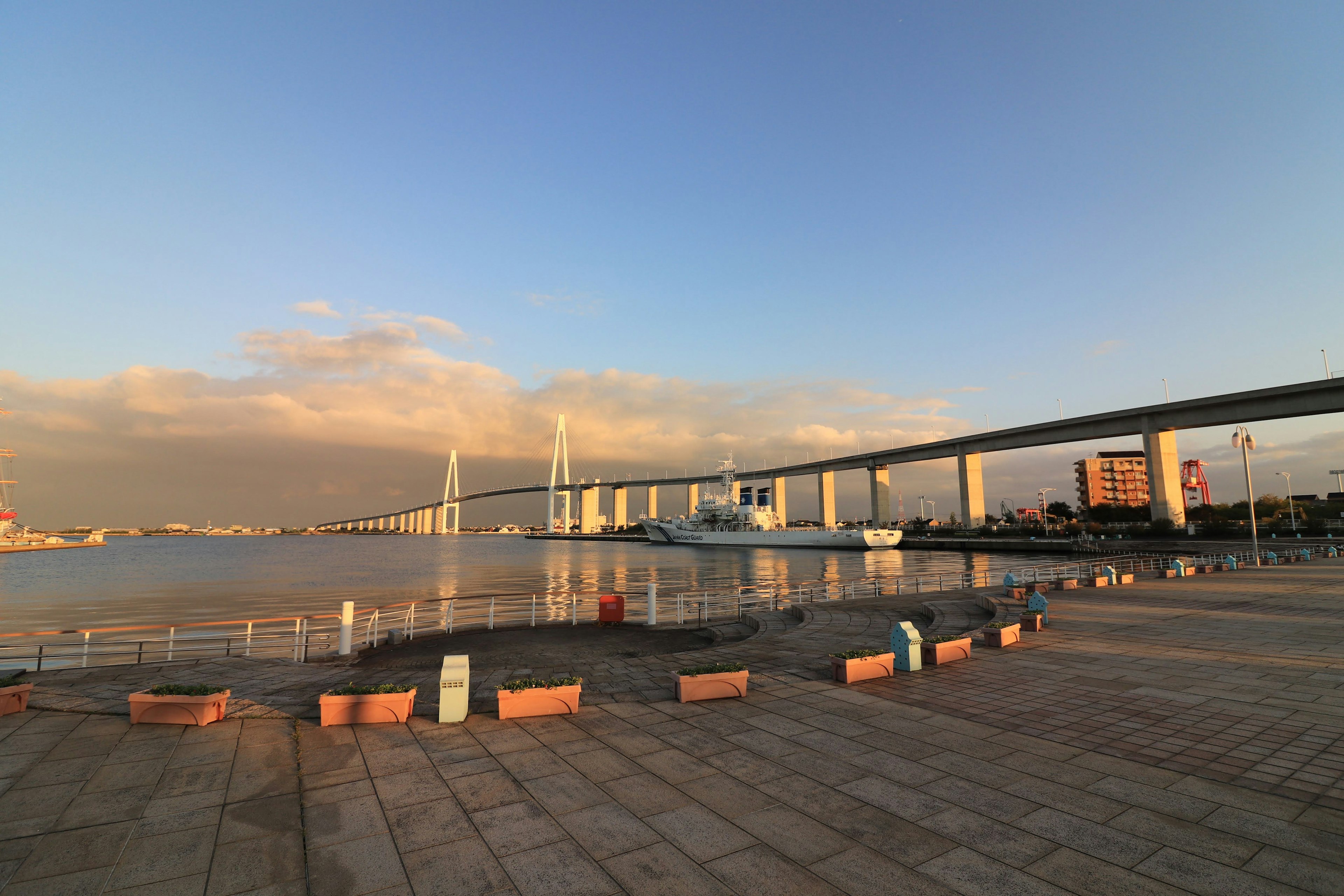 Malersicher Blick auf eine Brücke, die sich im Wasser bei Sonnenuntergang spiegelt