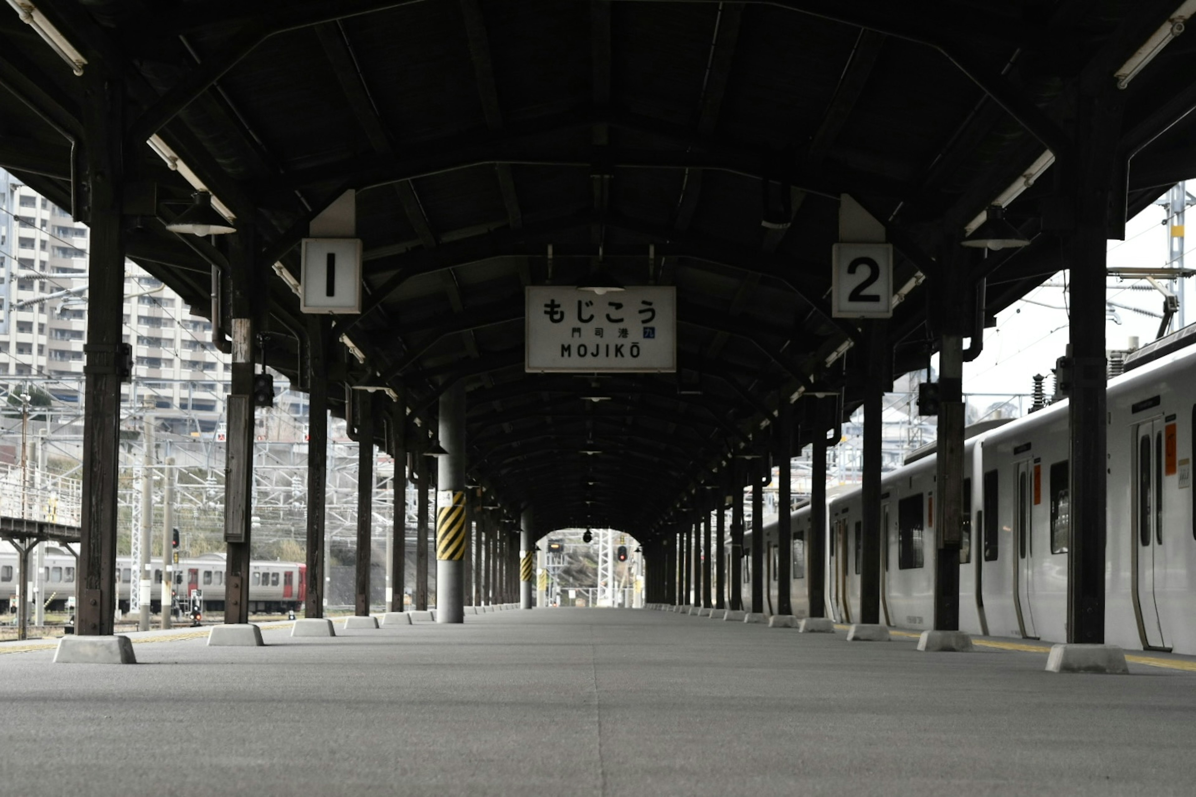 Interior view of a train station platform with signs and structural elements