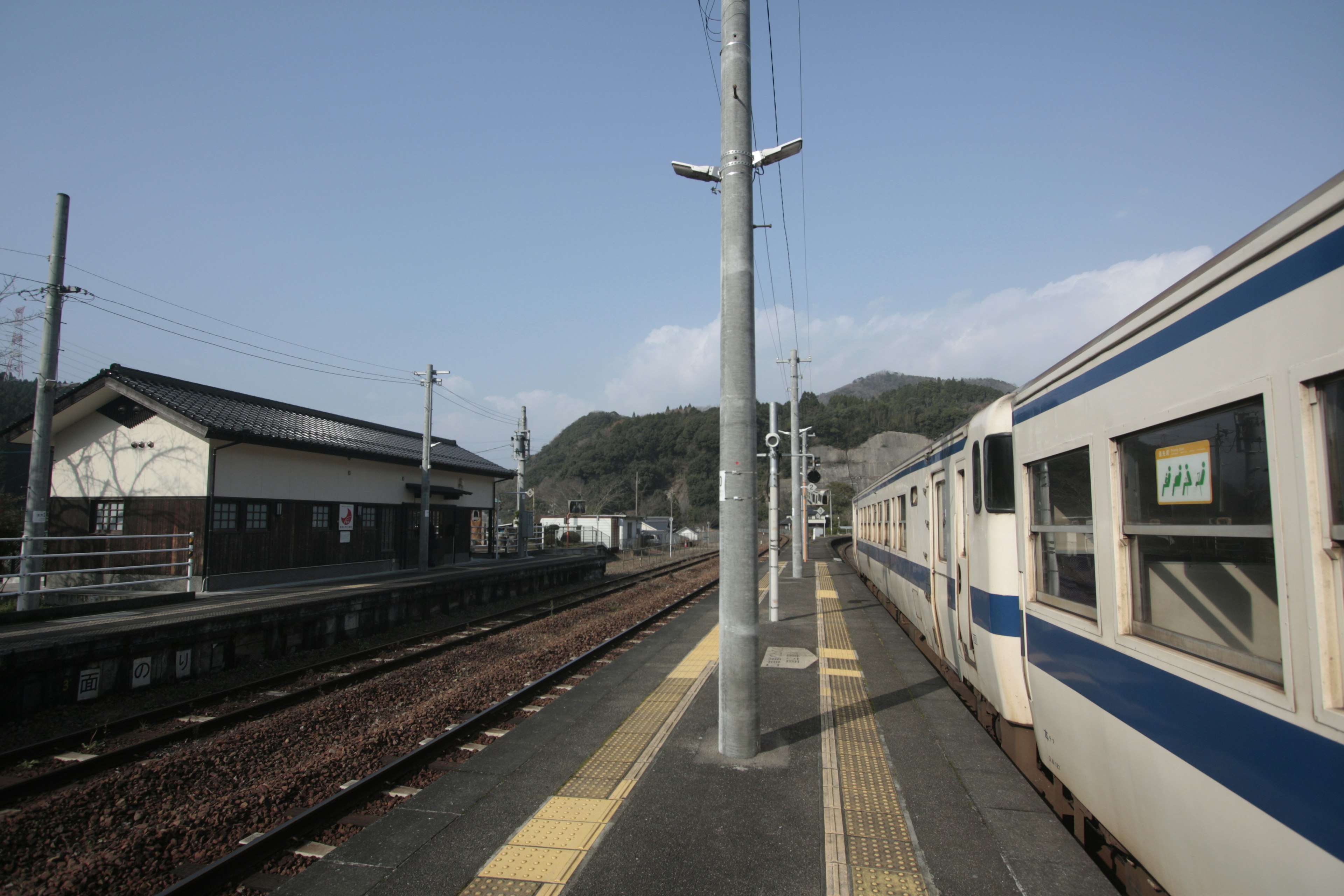 Train at a station platform with mountains in the background