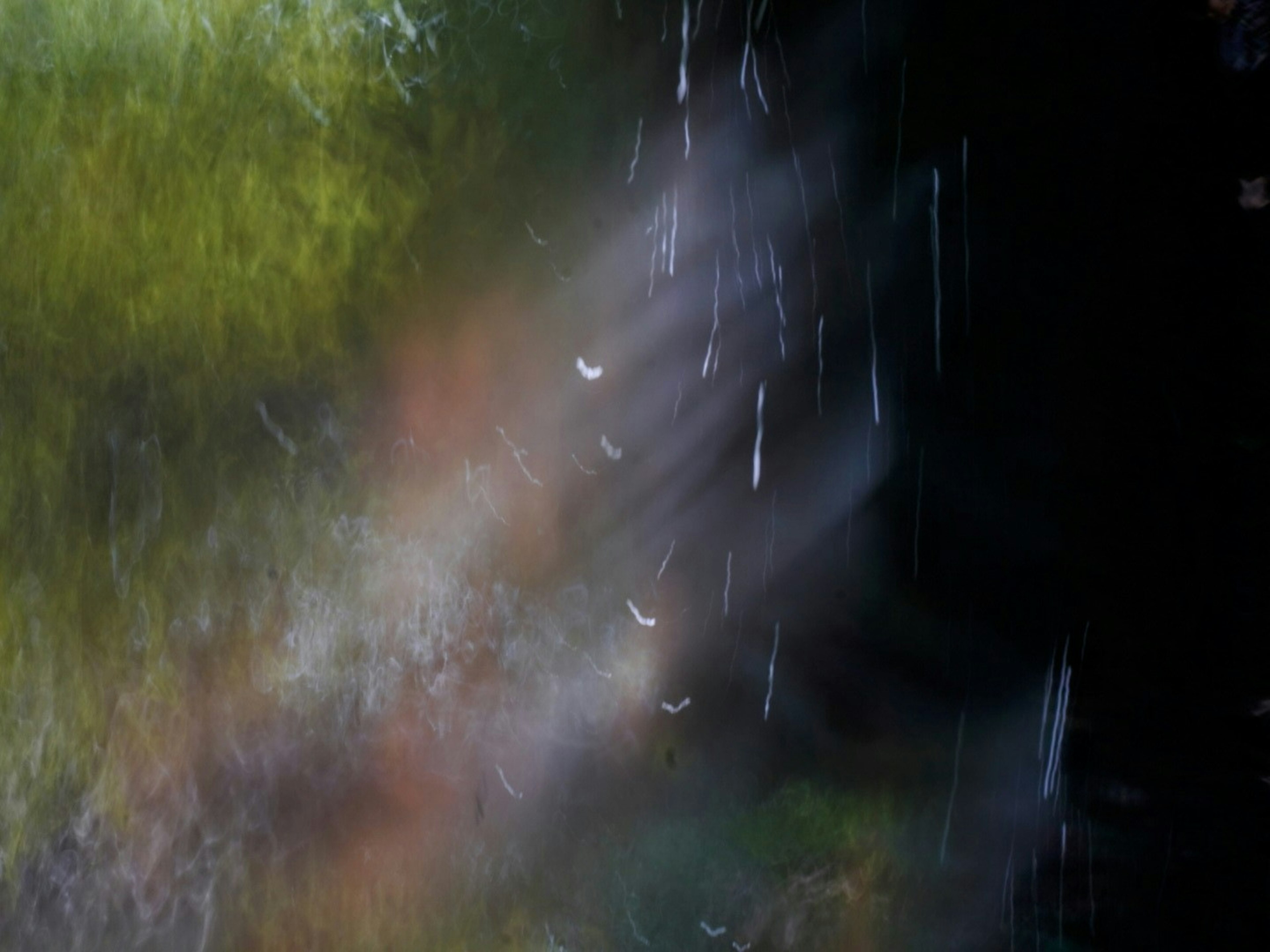 Abstract image showcasing flowing water with blurred background and color variations