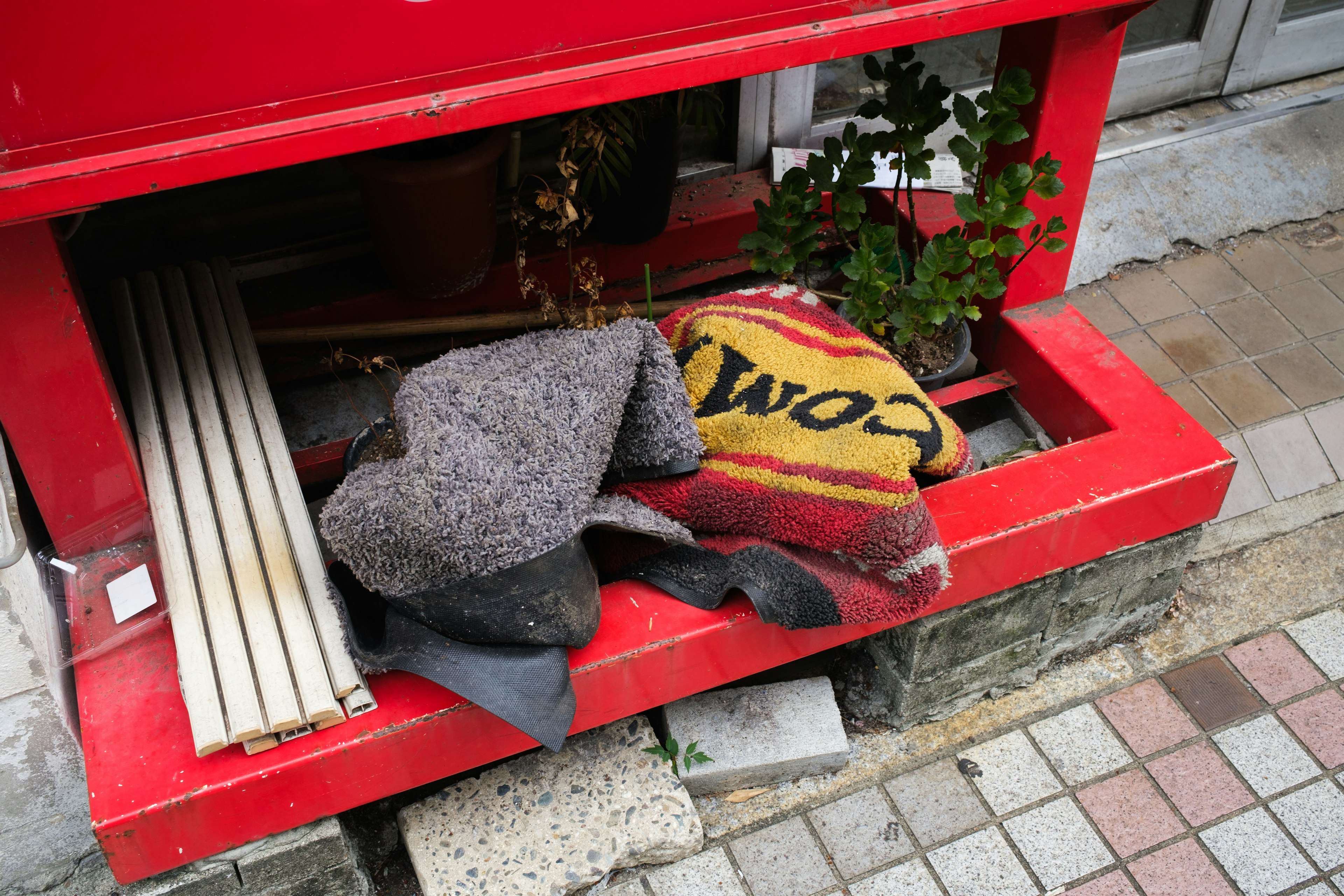 Mantas y plantas colocadas debajo de un buzón rojo