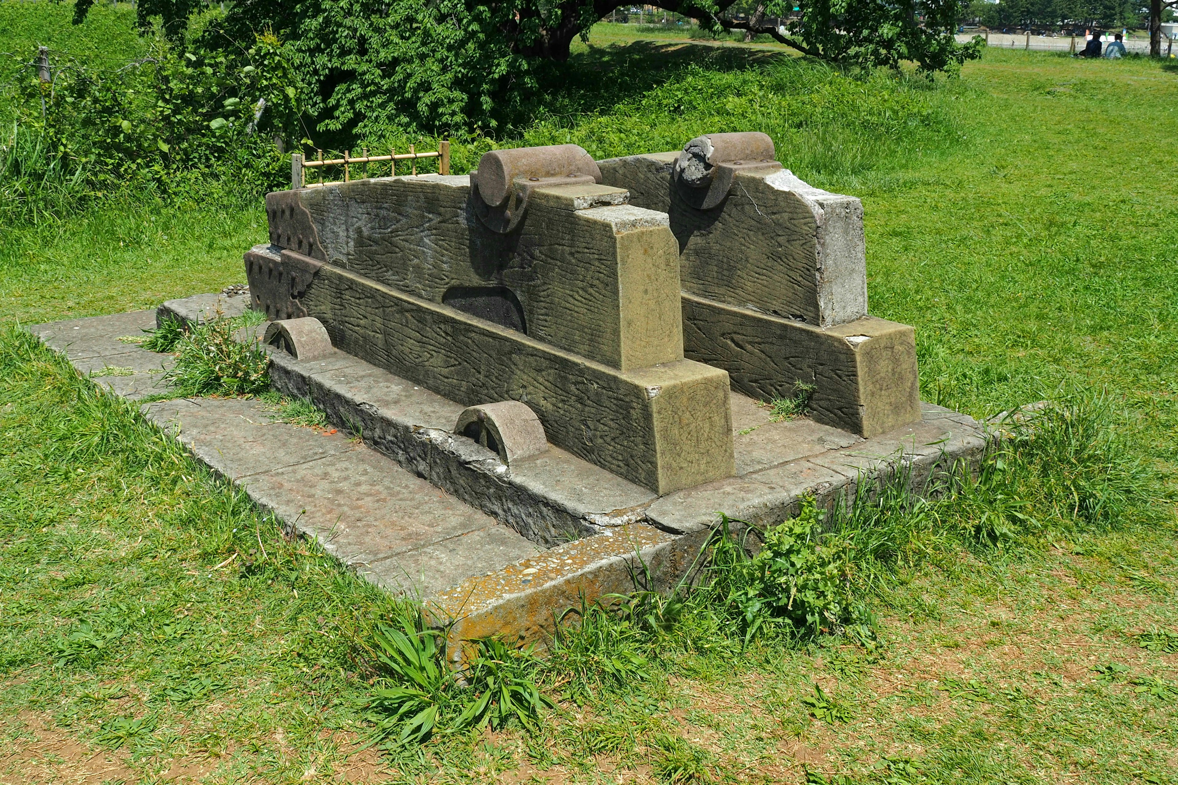 Two ancient stone structures surrounded by grass