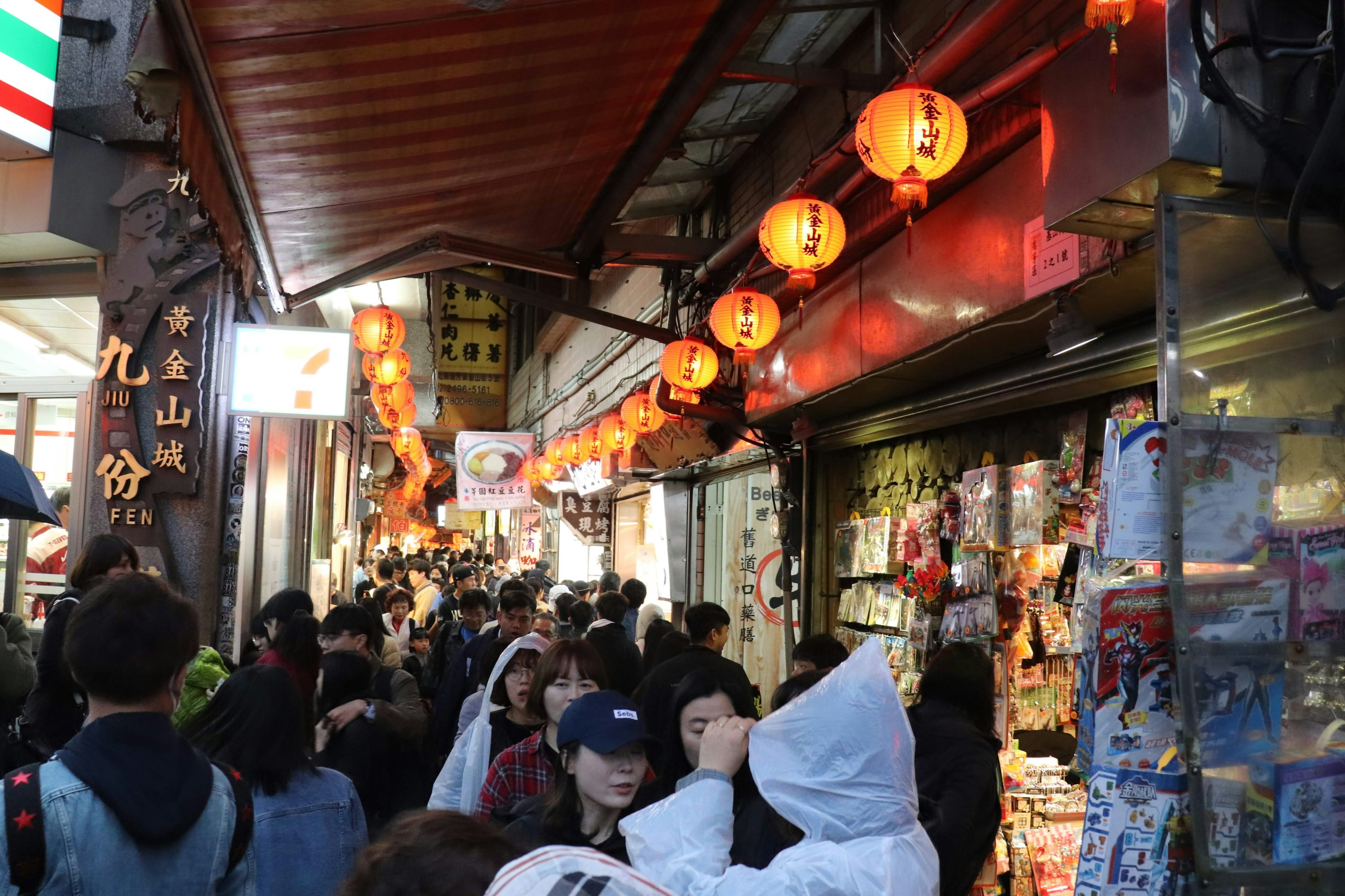 Viale commerciale affollato con lanterne rosse e folle di persone