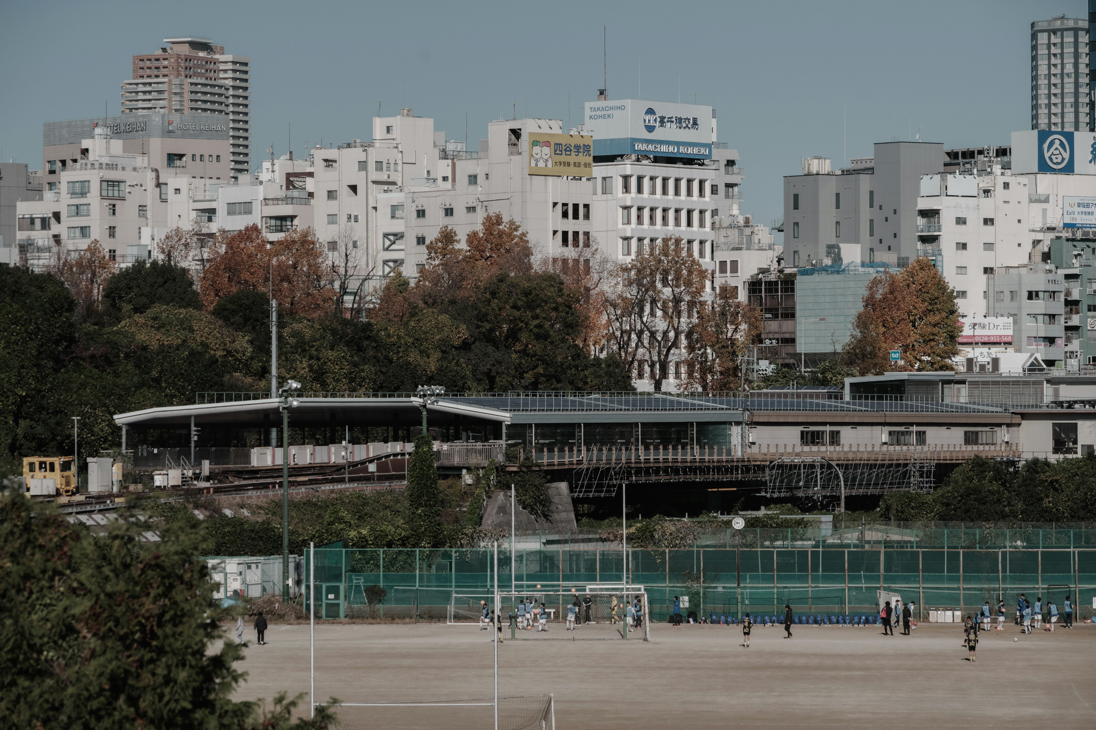 Städtische Landschaft mit einem Fußballfeld und einem Bahnhofgebäude