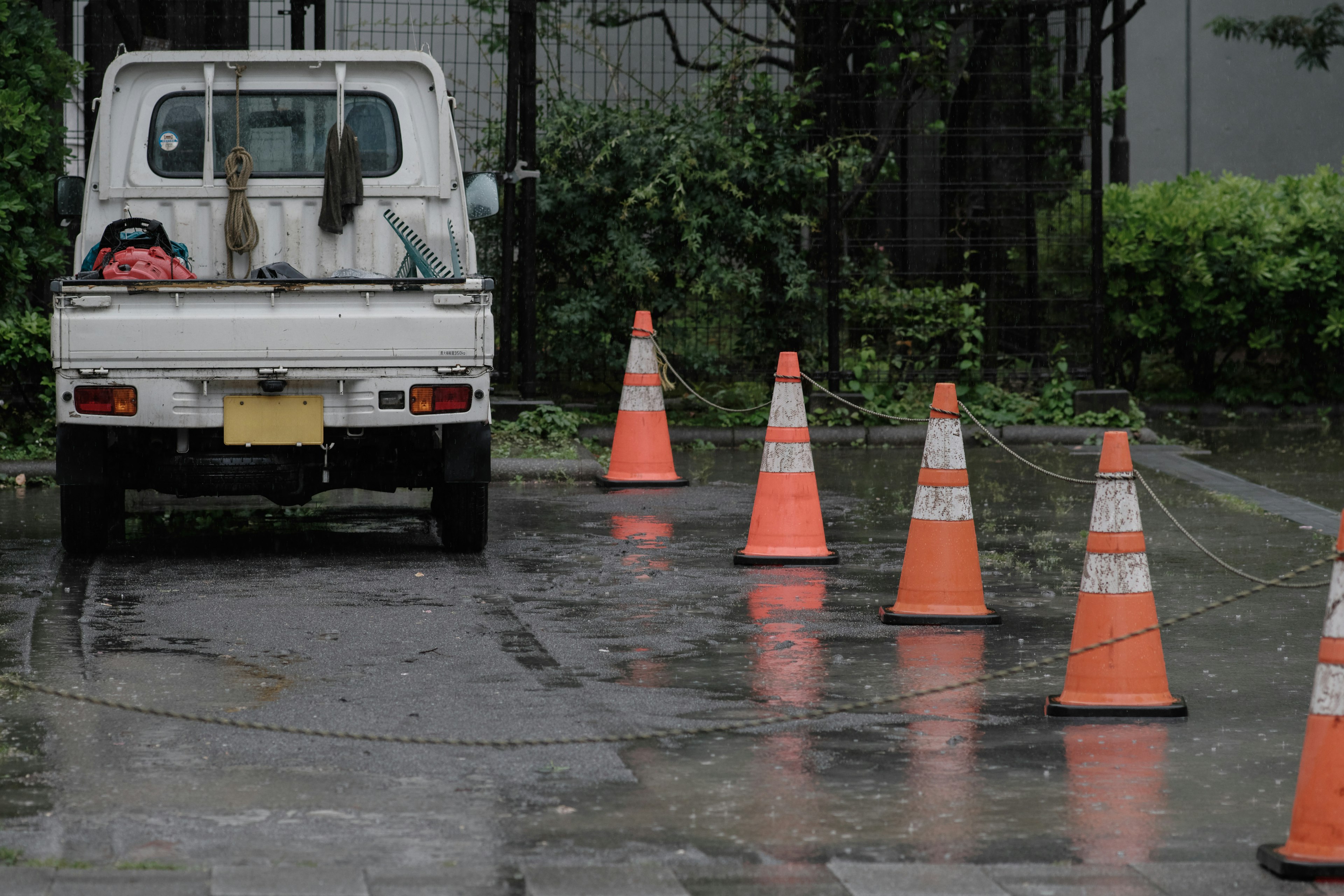 Camion blanc garé sous la pluie avec des cônes de circulation orange