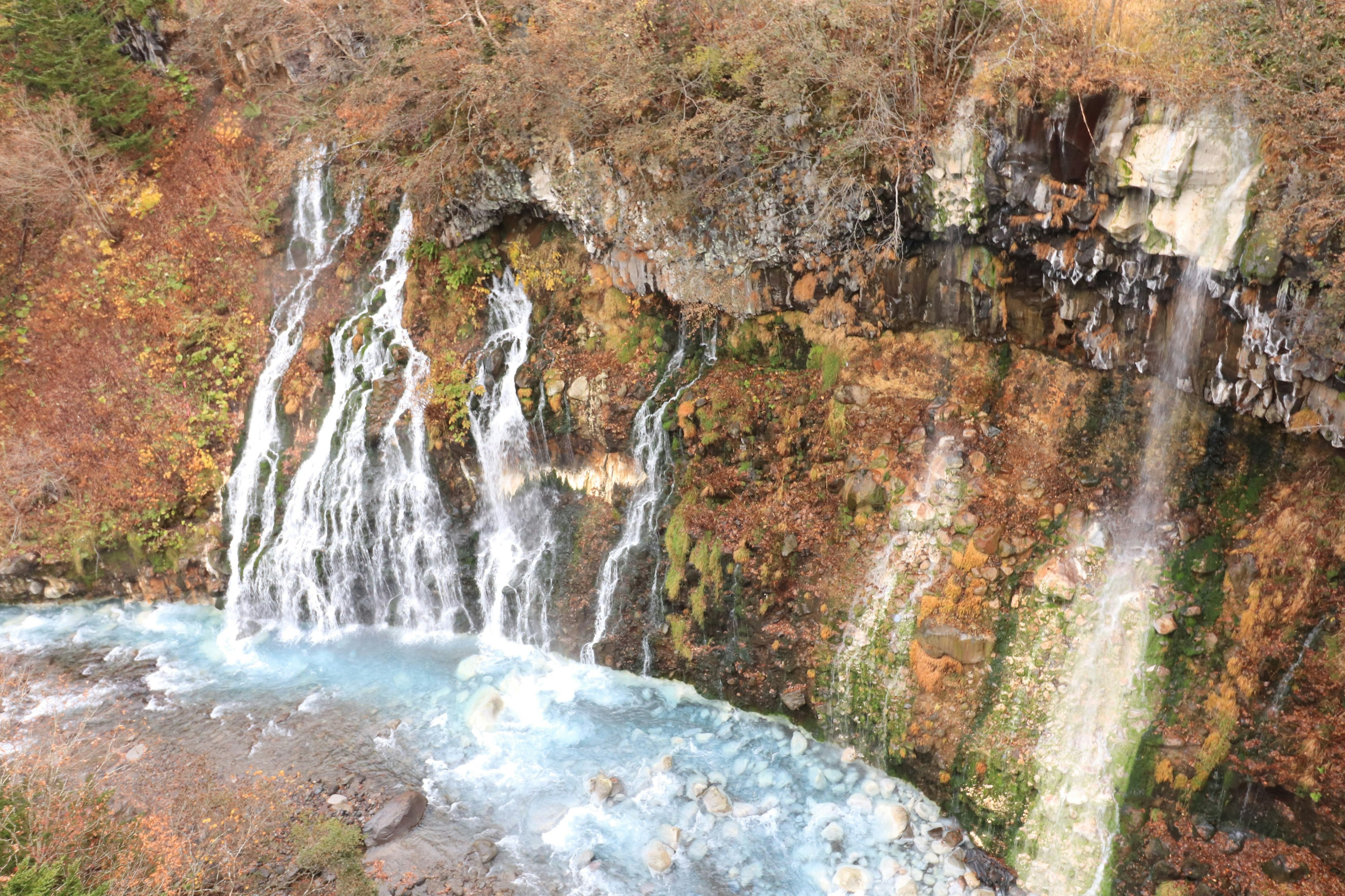 Una bella cascata che scorre su un terreno roccioso