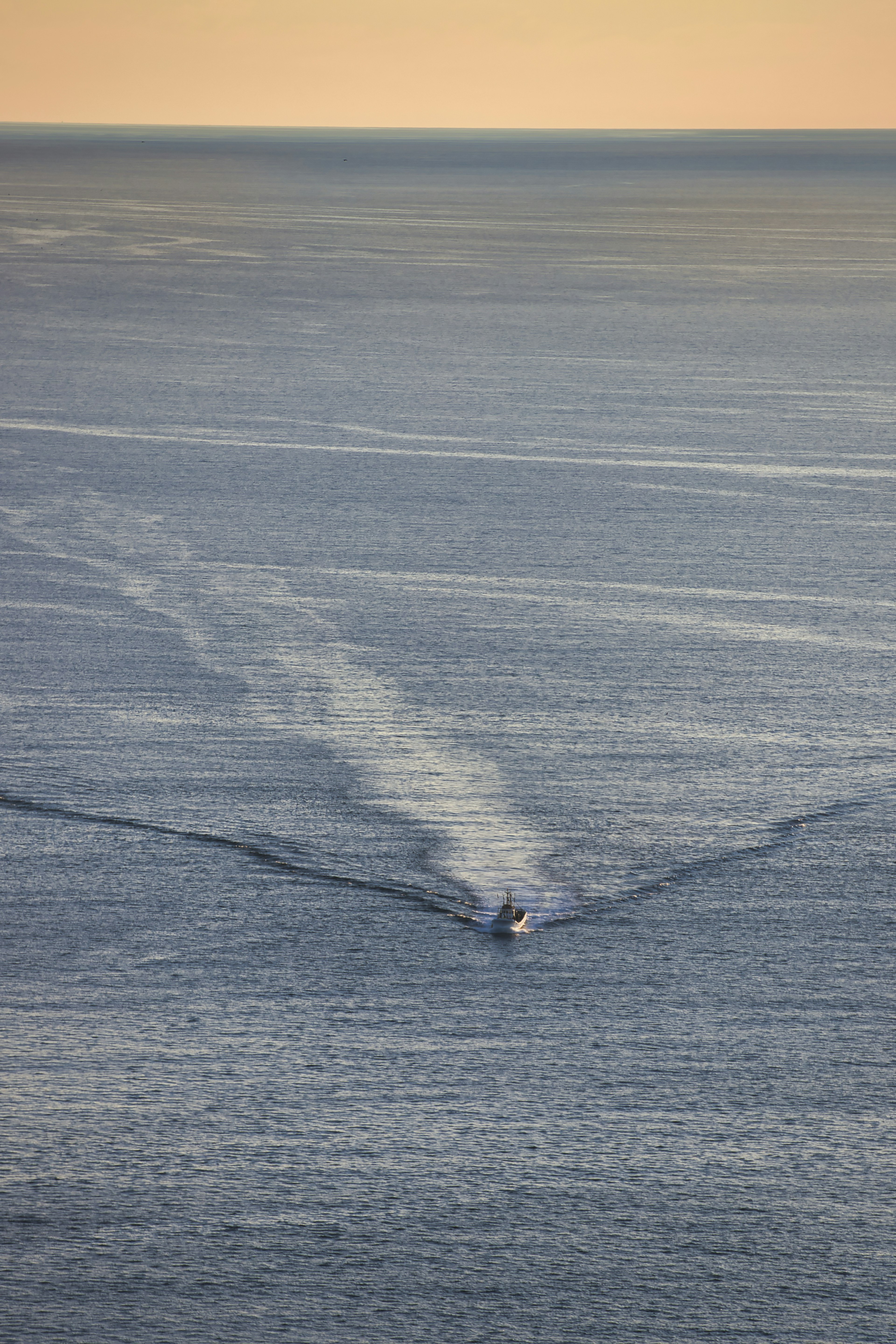 A small boat navigating on a blue ocean