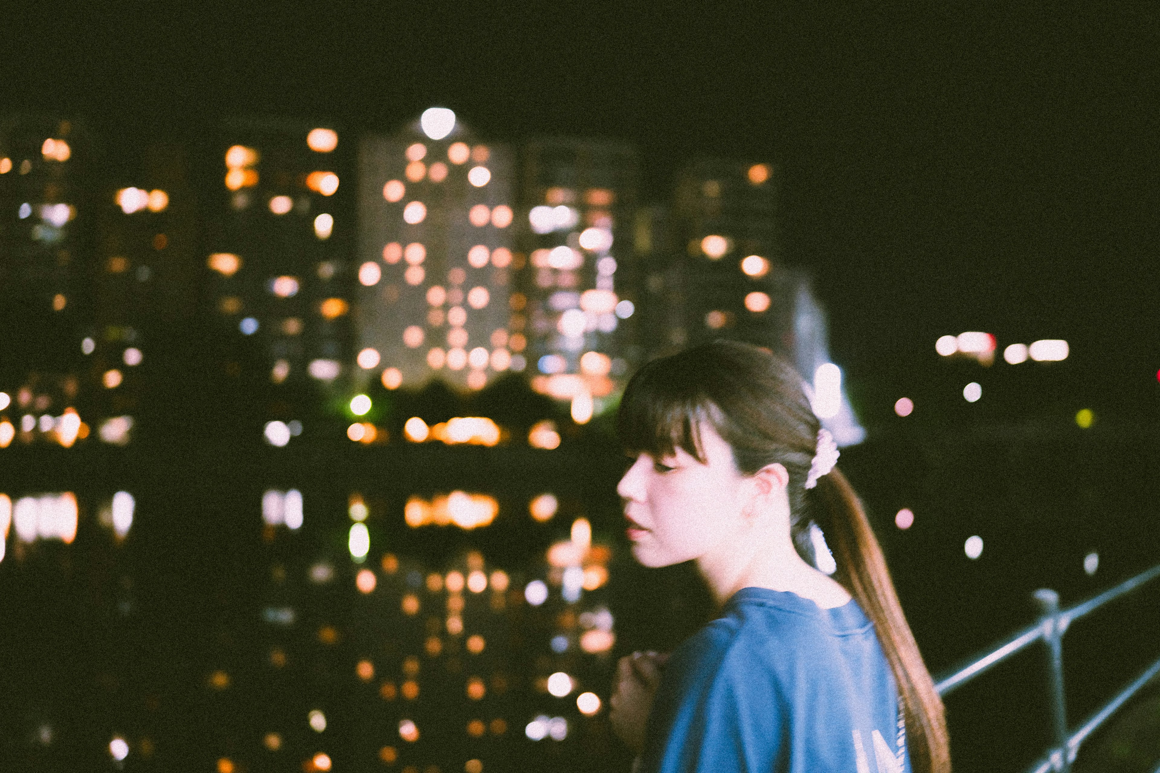 Profile of a woman against a city skyline at night