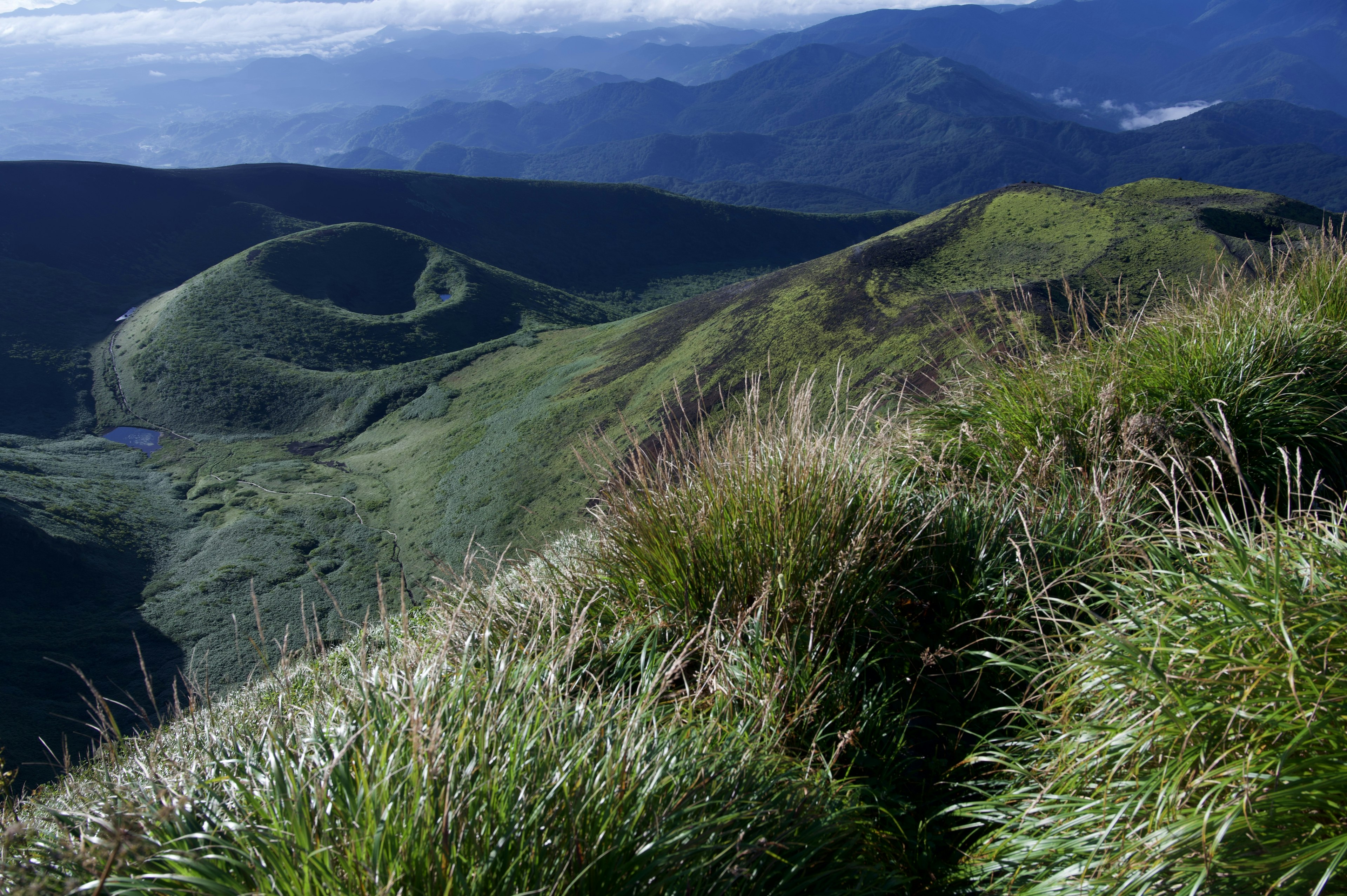 Pemandangan gunung dengan bukit hijau dan padang rumput