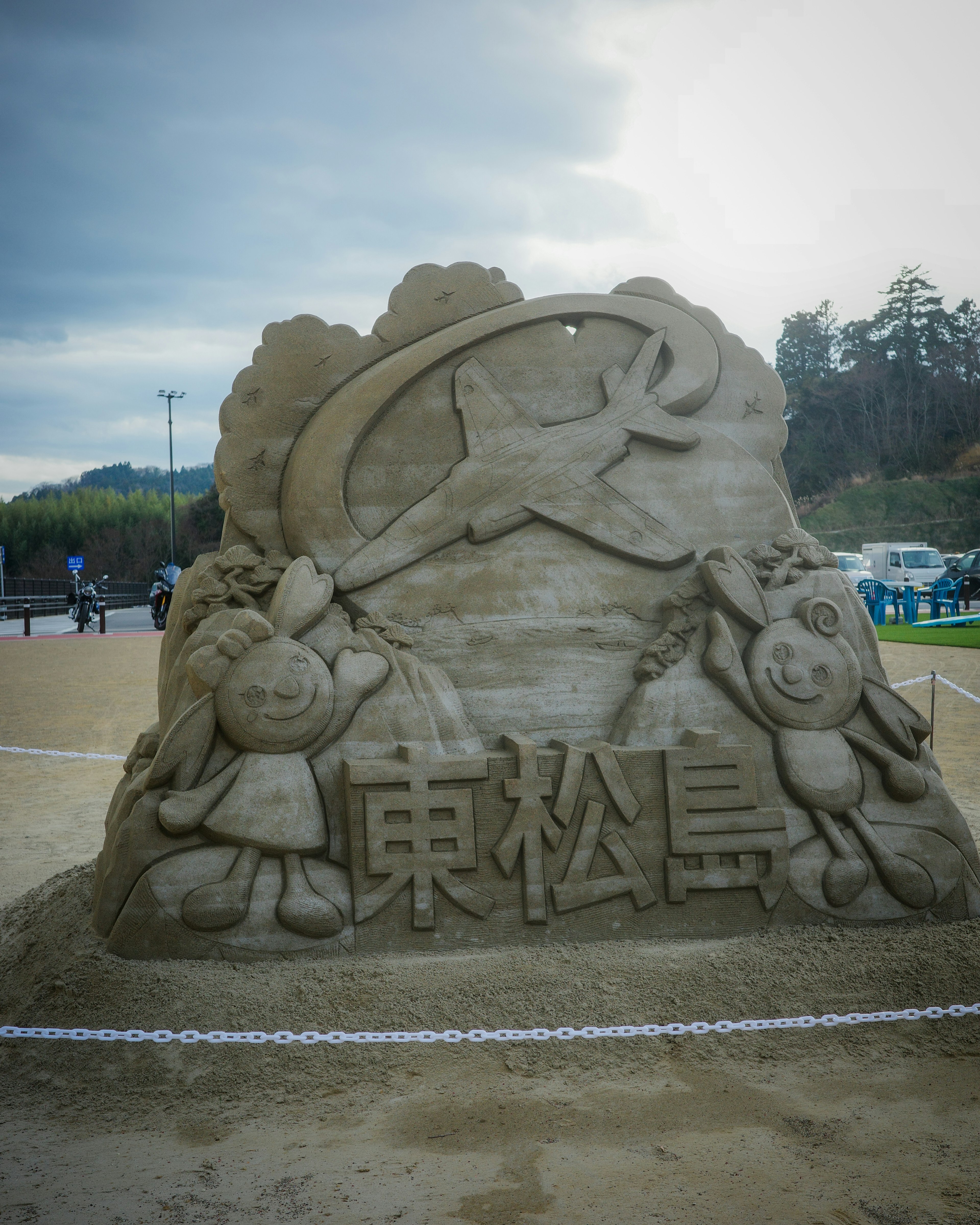 Sandskulptur, die das Symbol von Higashi-Matsushima und Charaktere darstellt