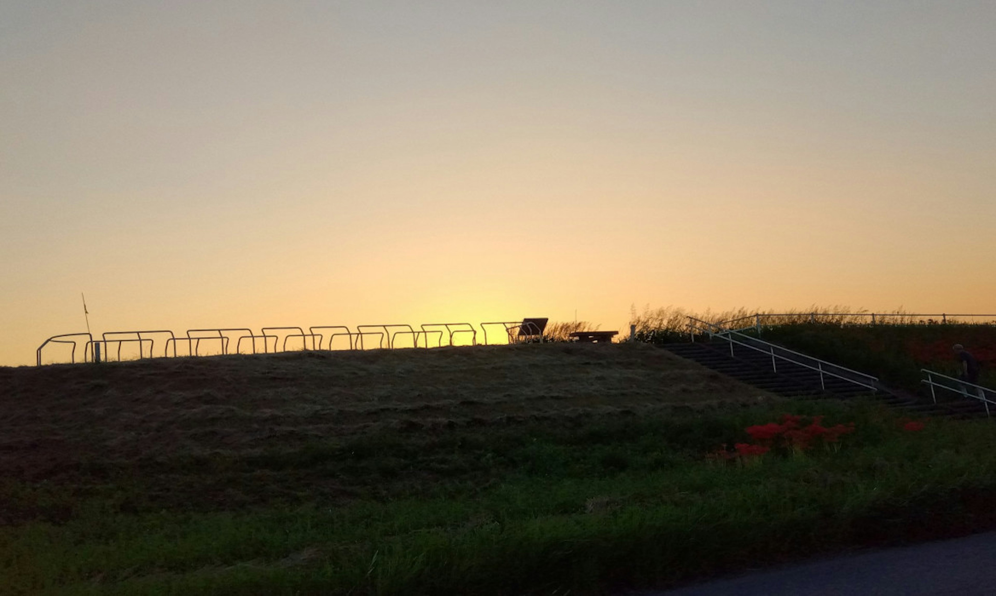 夕陽下的山丘輪廓和圍欄