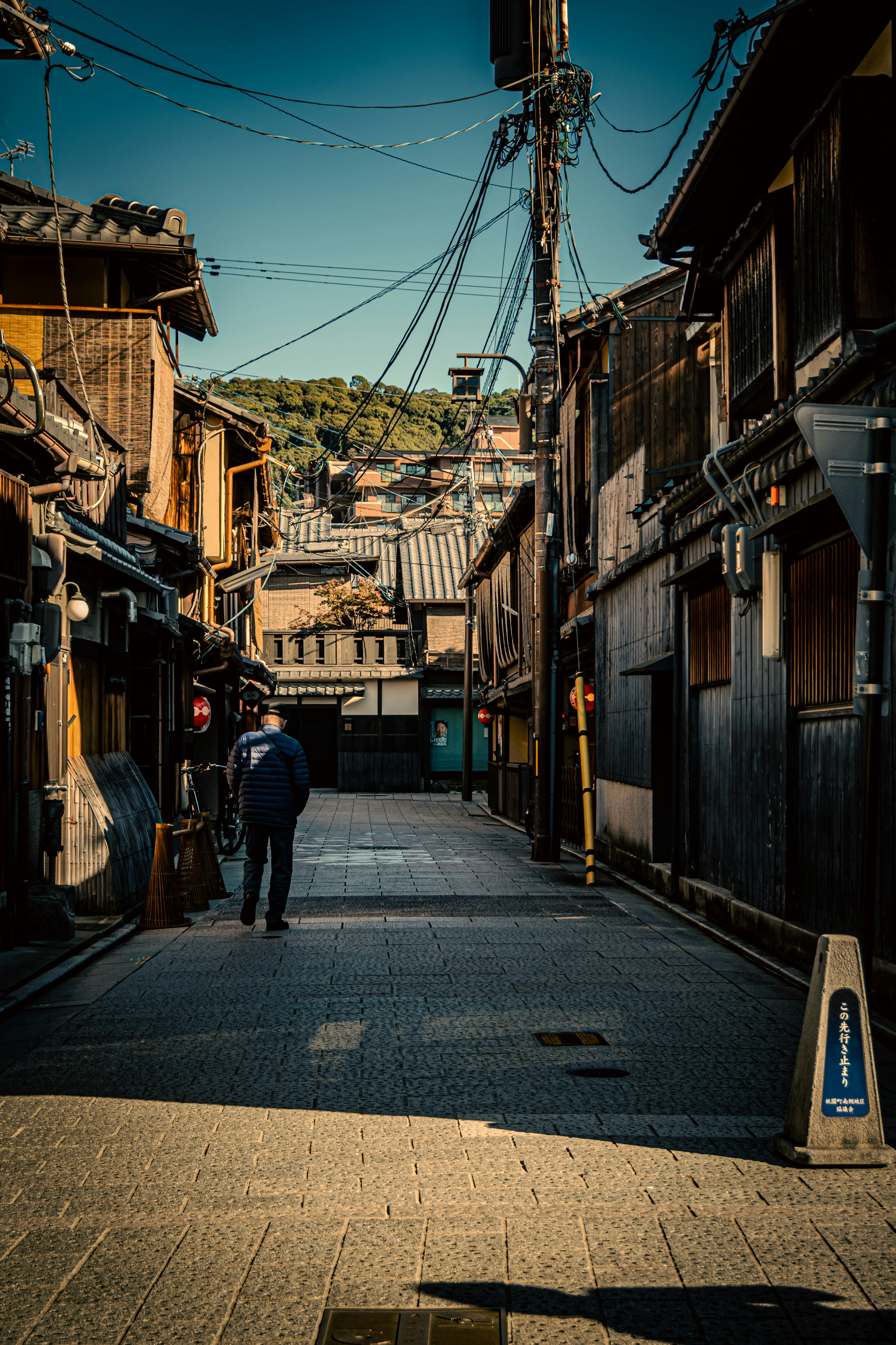 静かな街並みを歩く人の姿が見える古い木造の建物