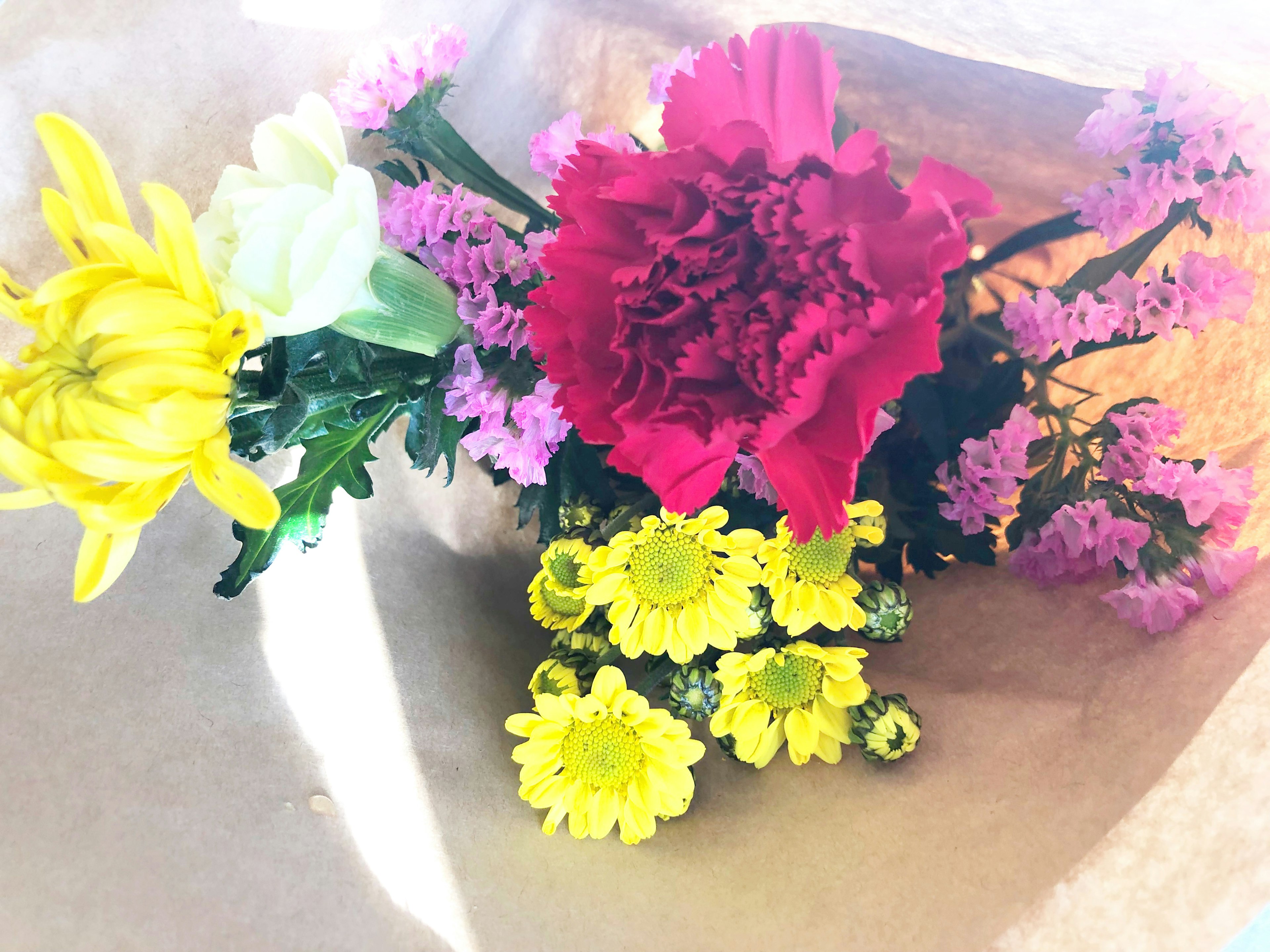 Un bouquet coloré avec une œillet rouge et des fleurs jaunes