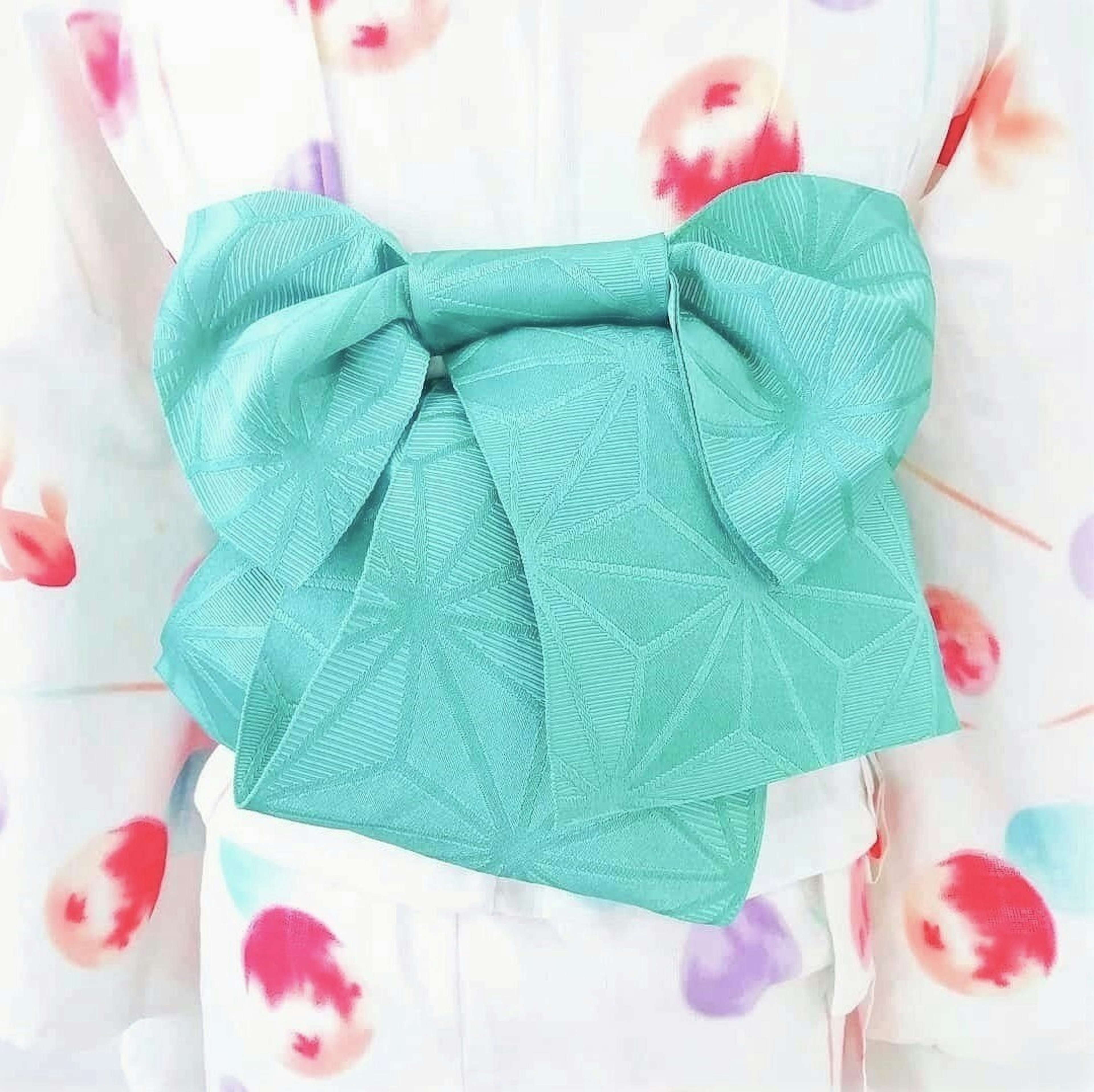 Kimono putih dengan pola bunga berwarna-warni dan obi teal