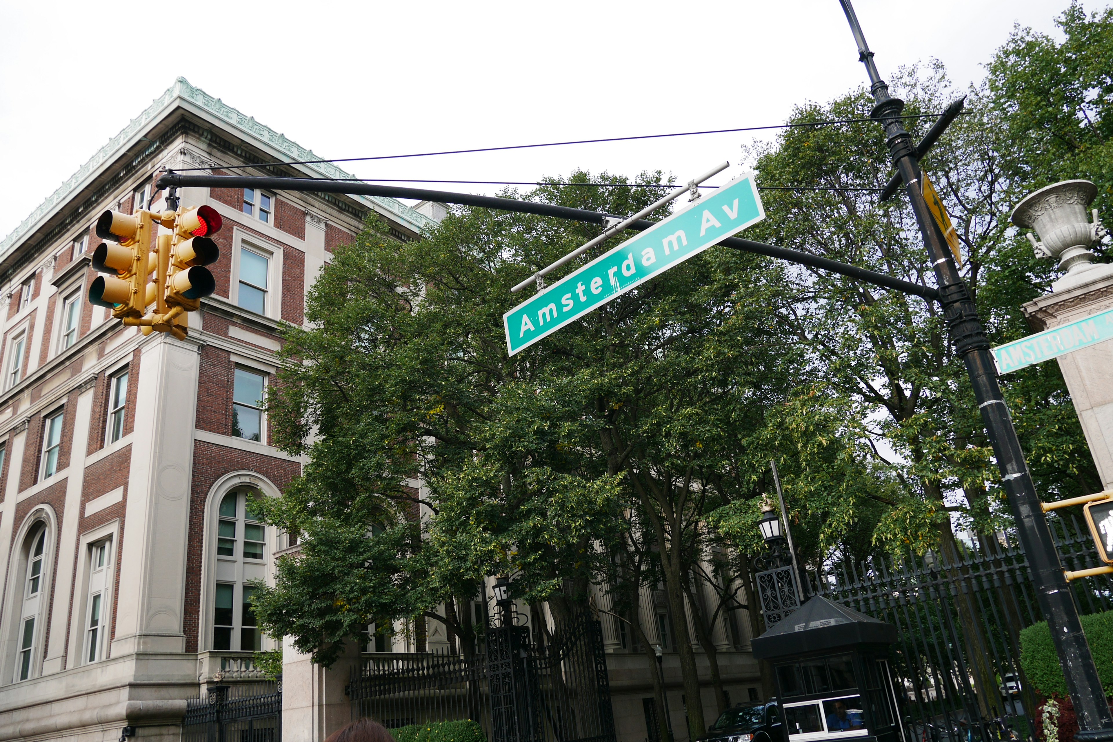 Insegna stradale per Amsterdam Avenue con semaforo in primo piano