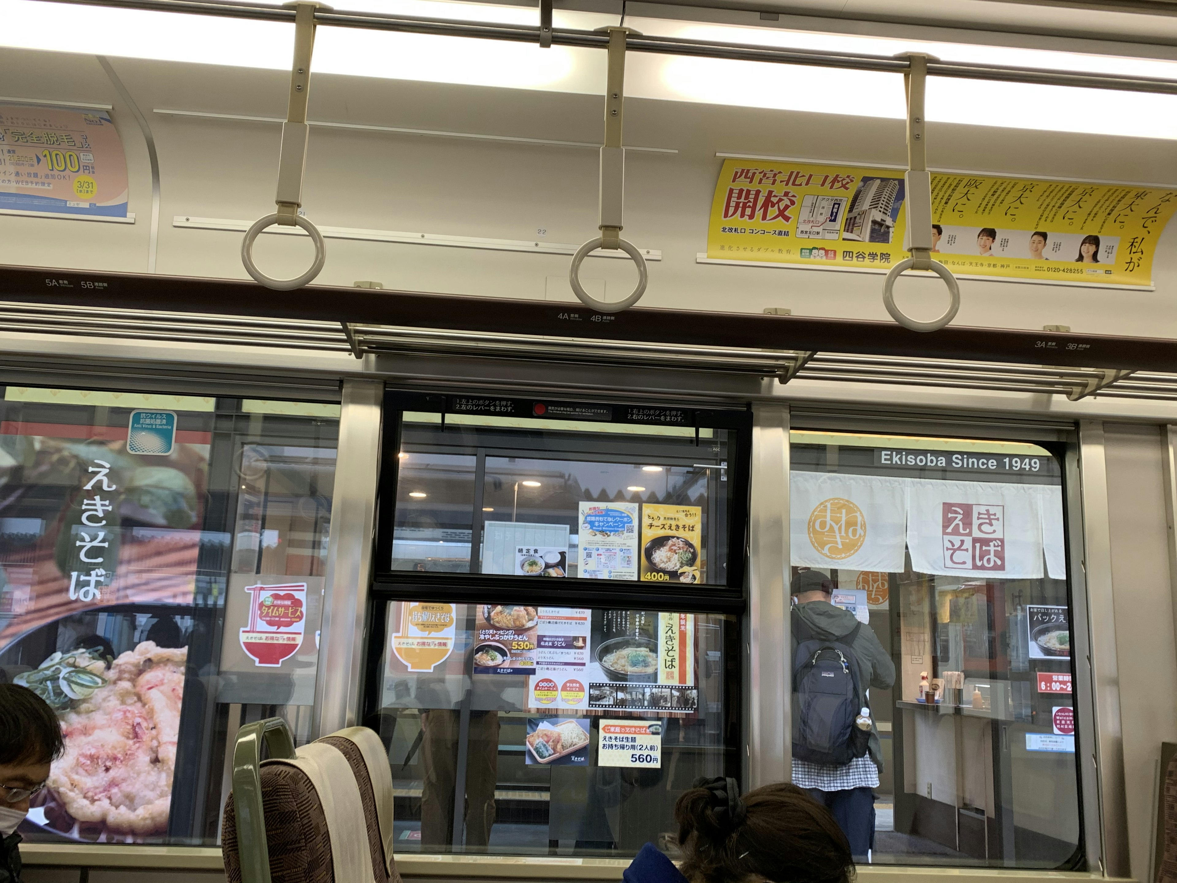 Intérieur d'un train avec vue sur des panneaux de restaurant à l'extérieur de la fenêtre