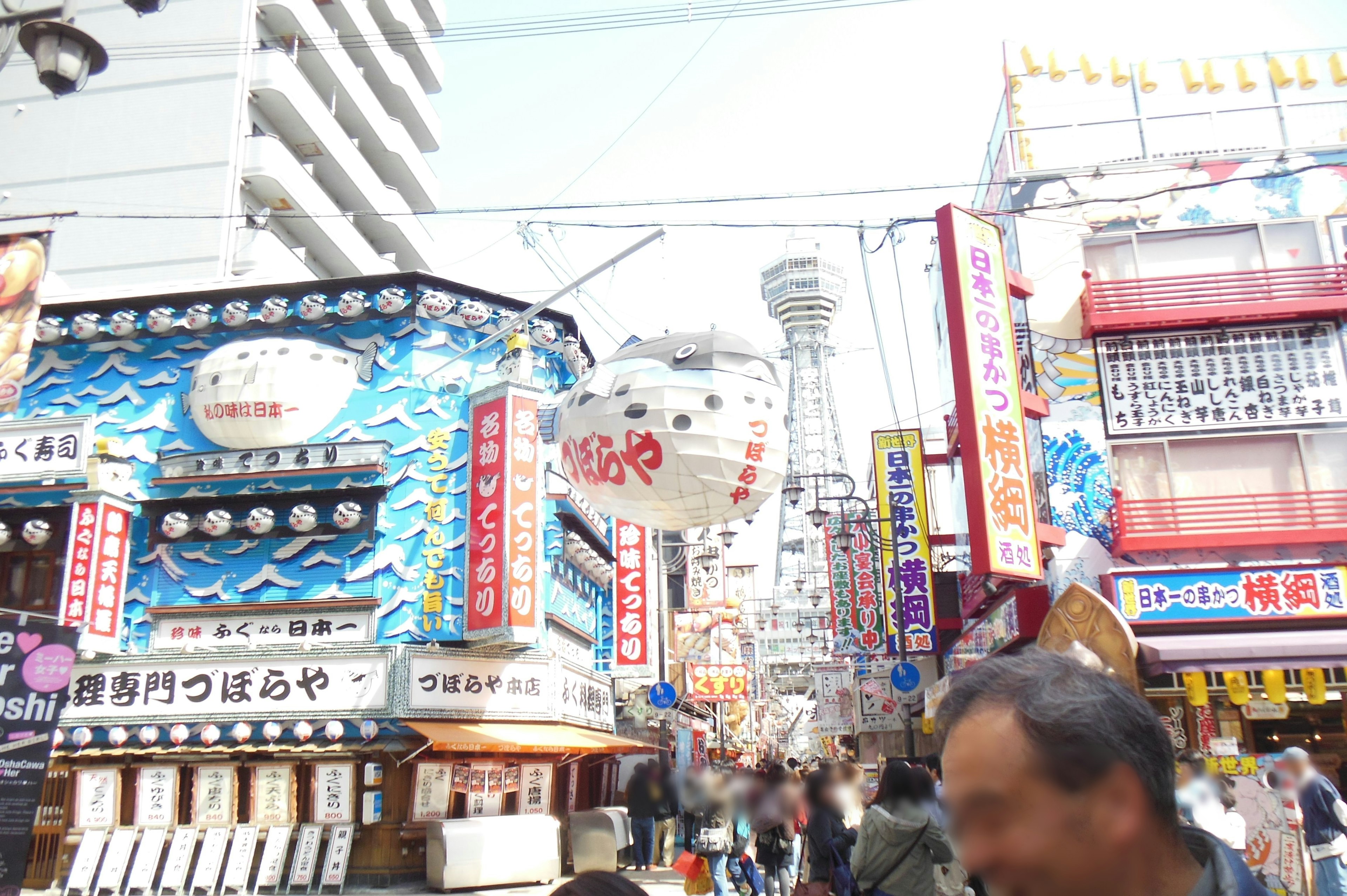 賑やかな街並みの写真で色とりどりの看板と人々が映る