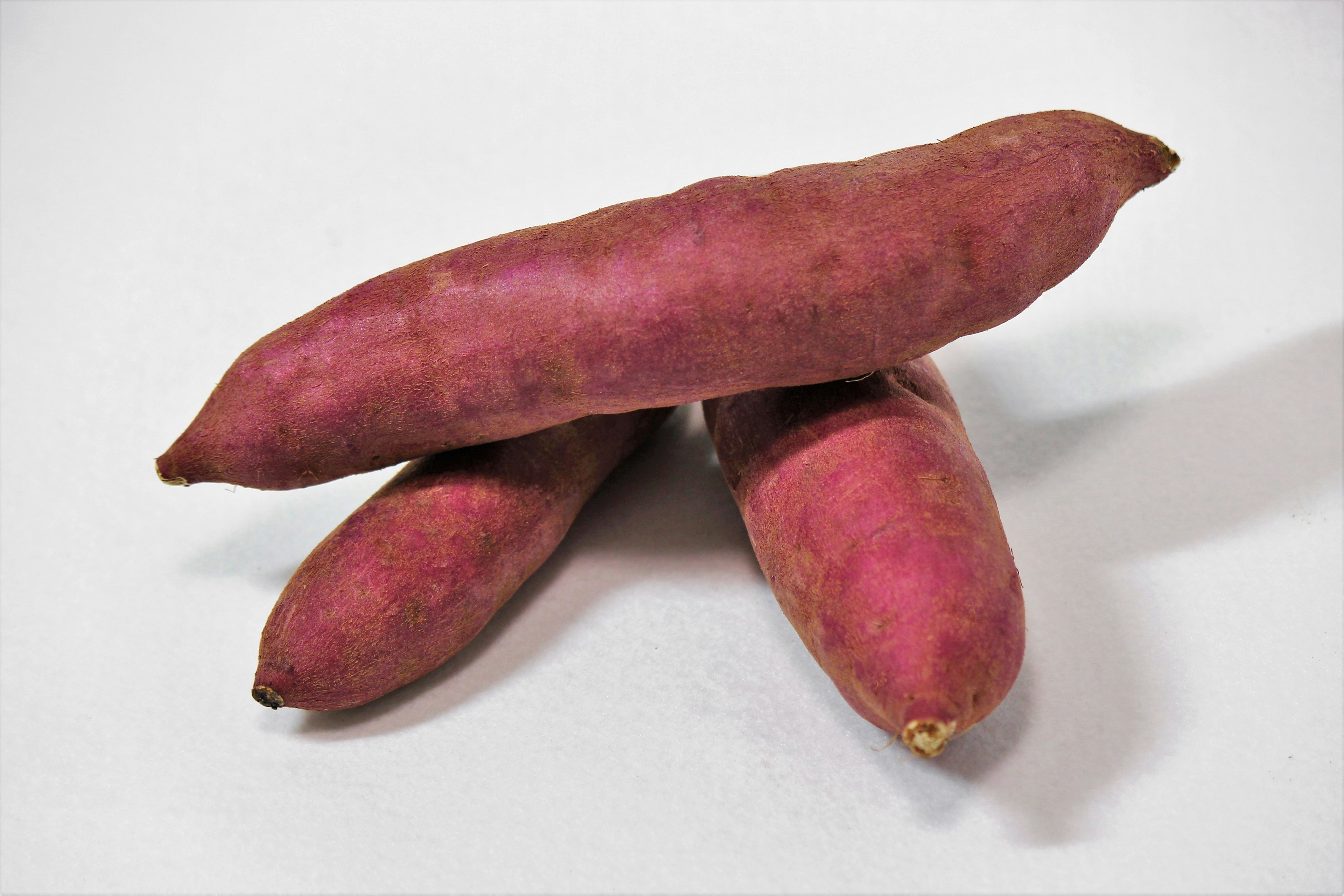 Three purple sweet potatoes stacked together