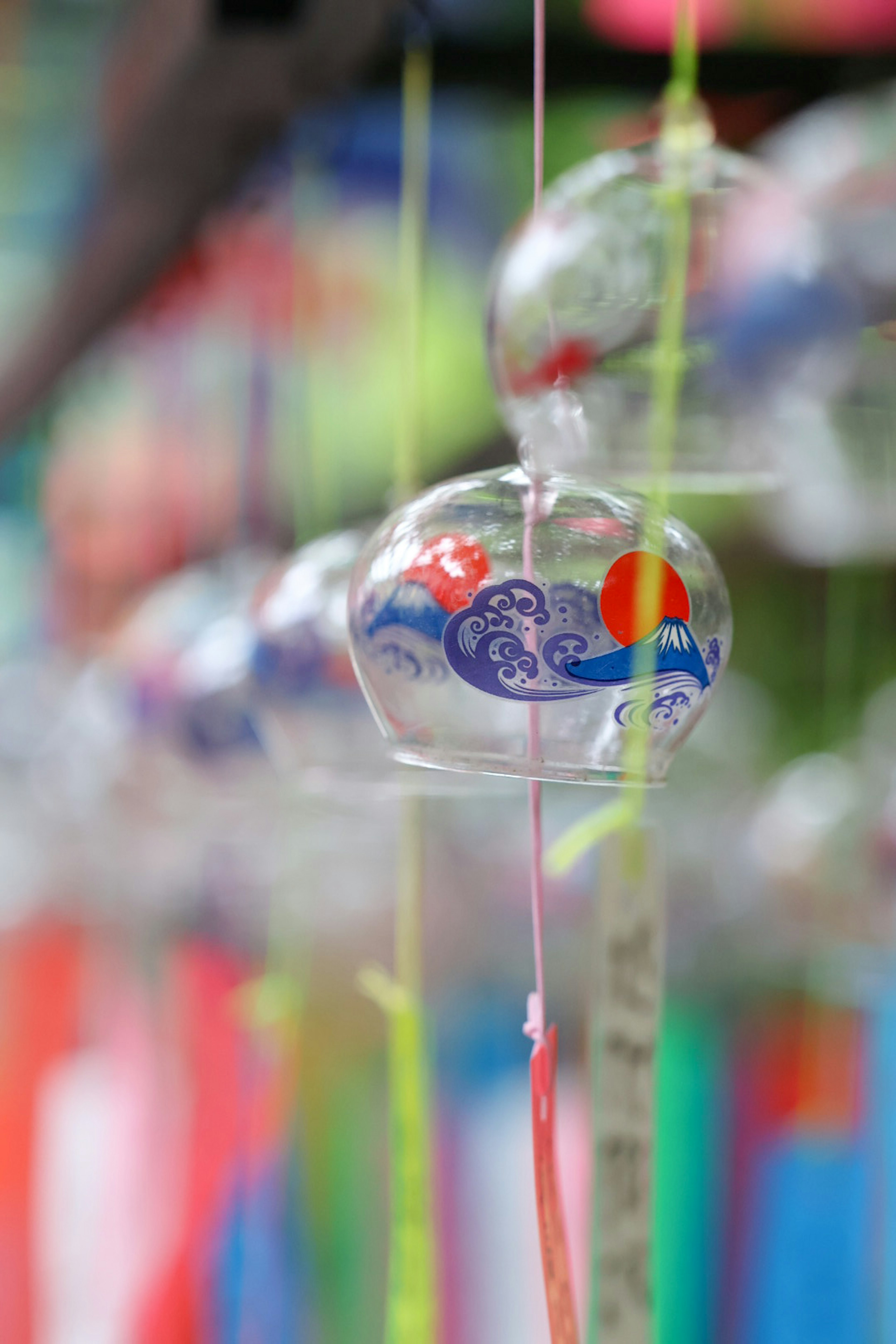 Cloche à vent en verre transparent avec un motif de vague bleue et de soleil rouge