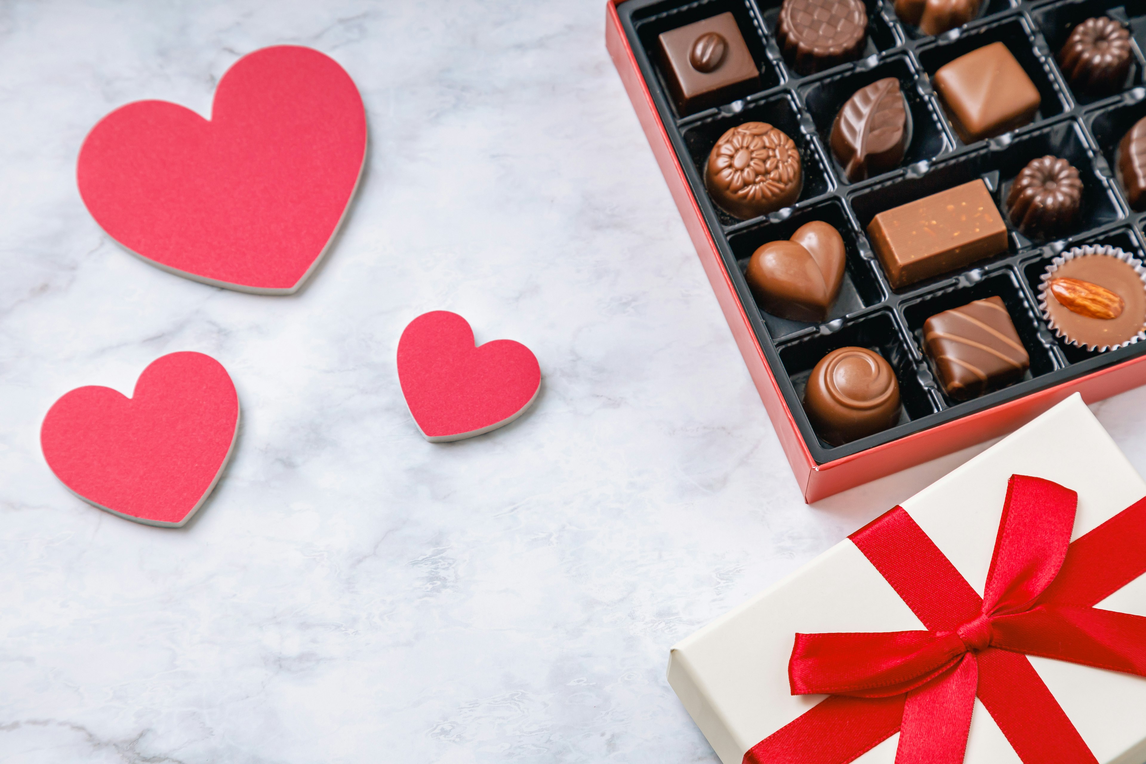 Romantic scene with red heart-shaped cards and a box of chocolates