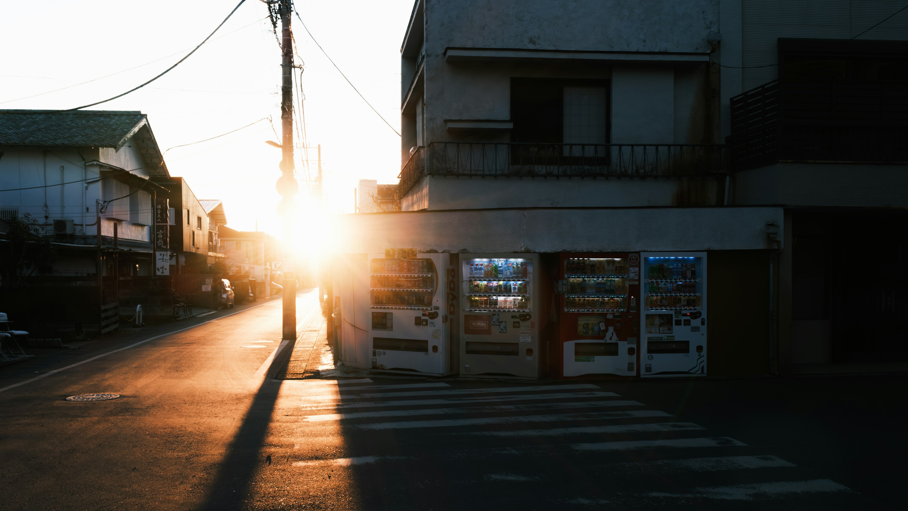 Vista di strada al tramonto con distributori automatici e edifici