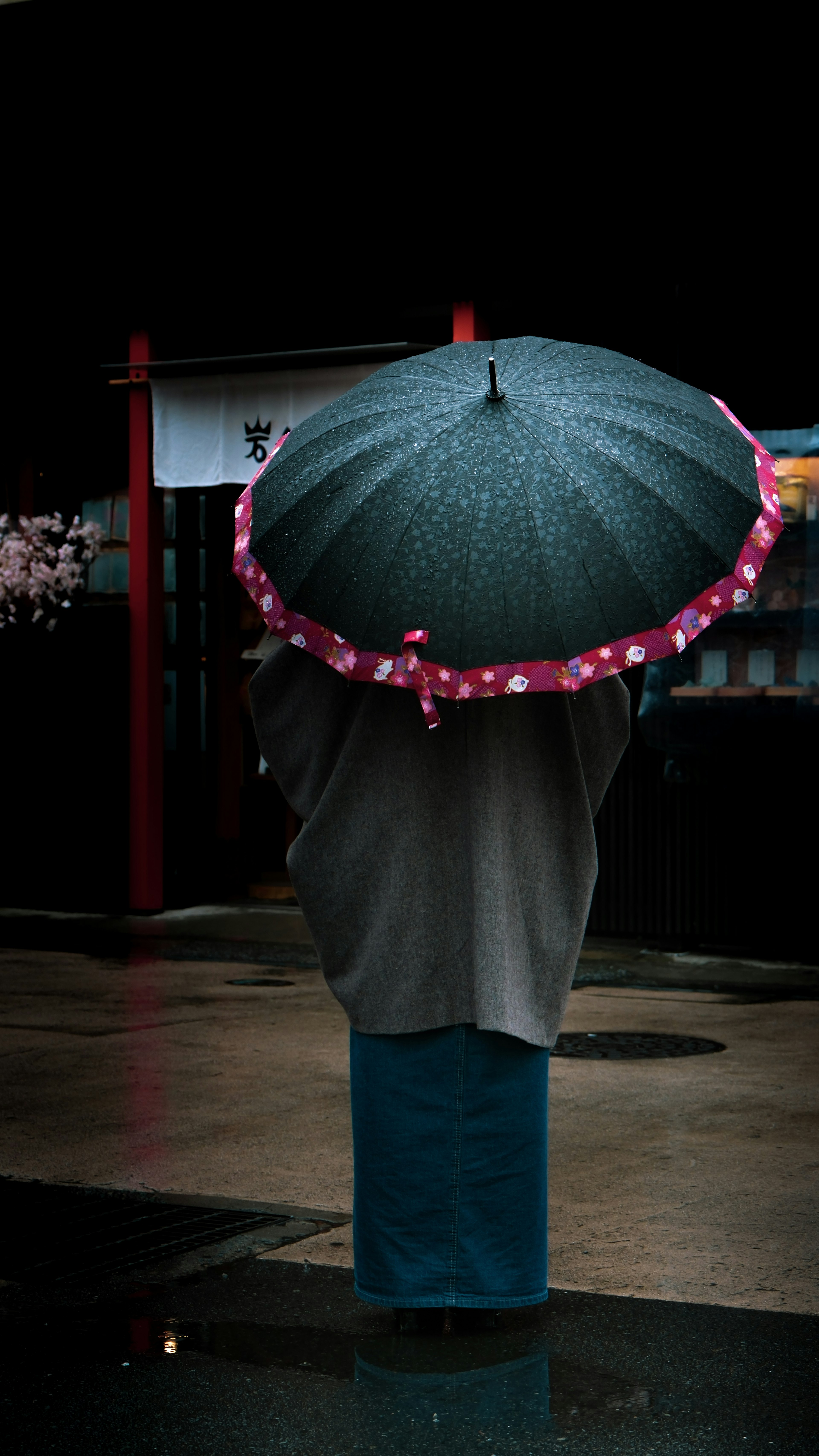 傘を持った人が雨の中に立っているシーン