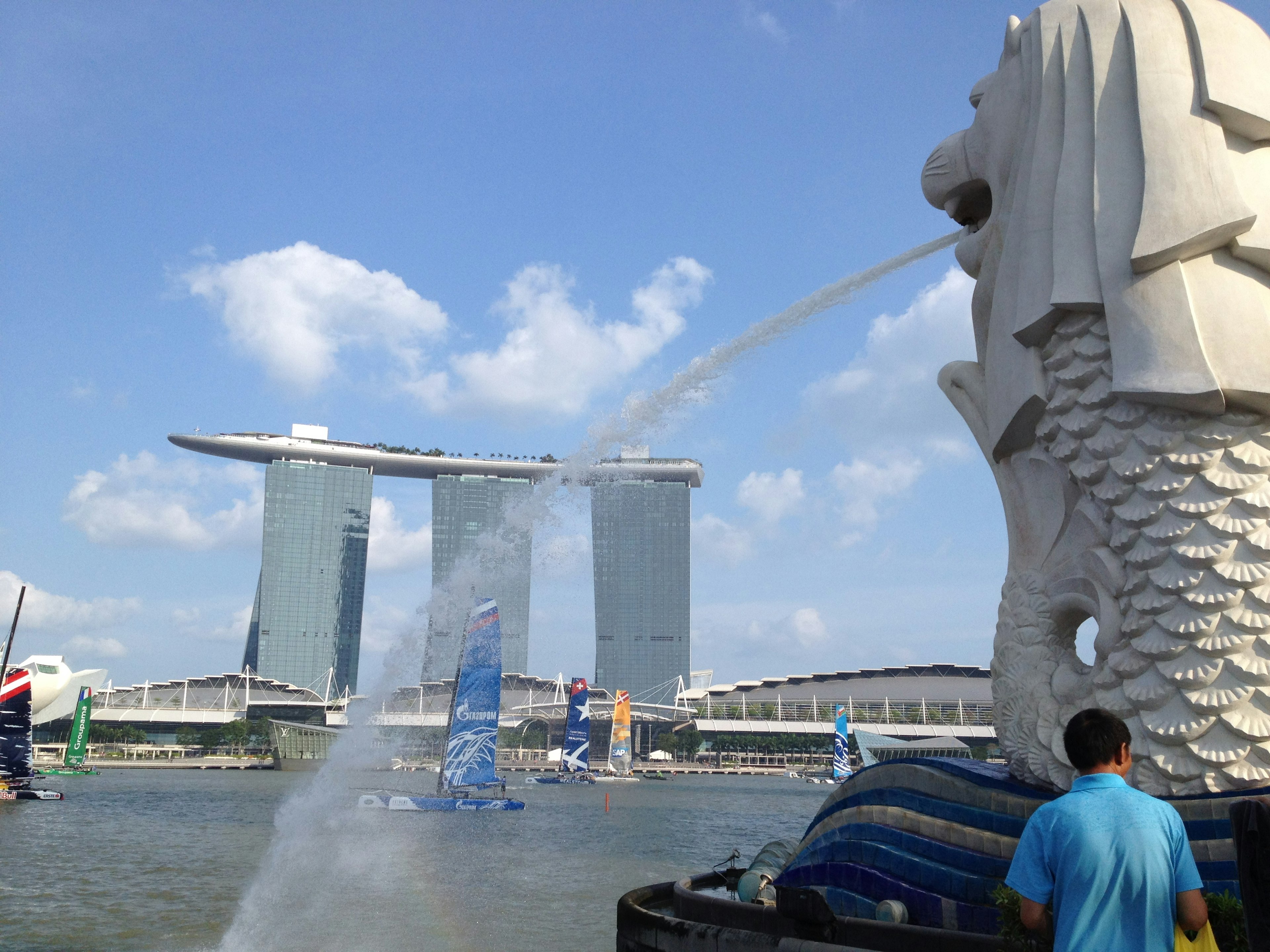 Statua del Merlion a Singapore che spruzza acqua con Marina Bay Sands sullo sfondo