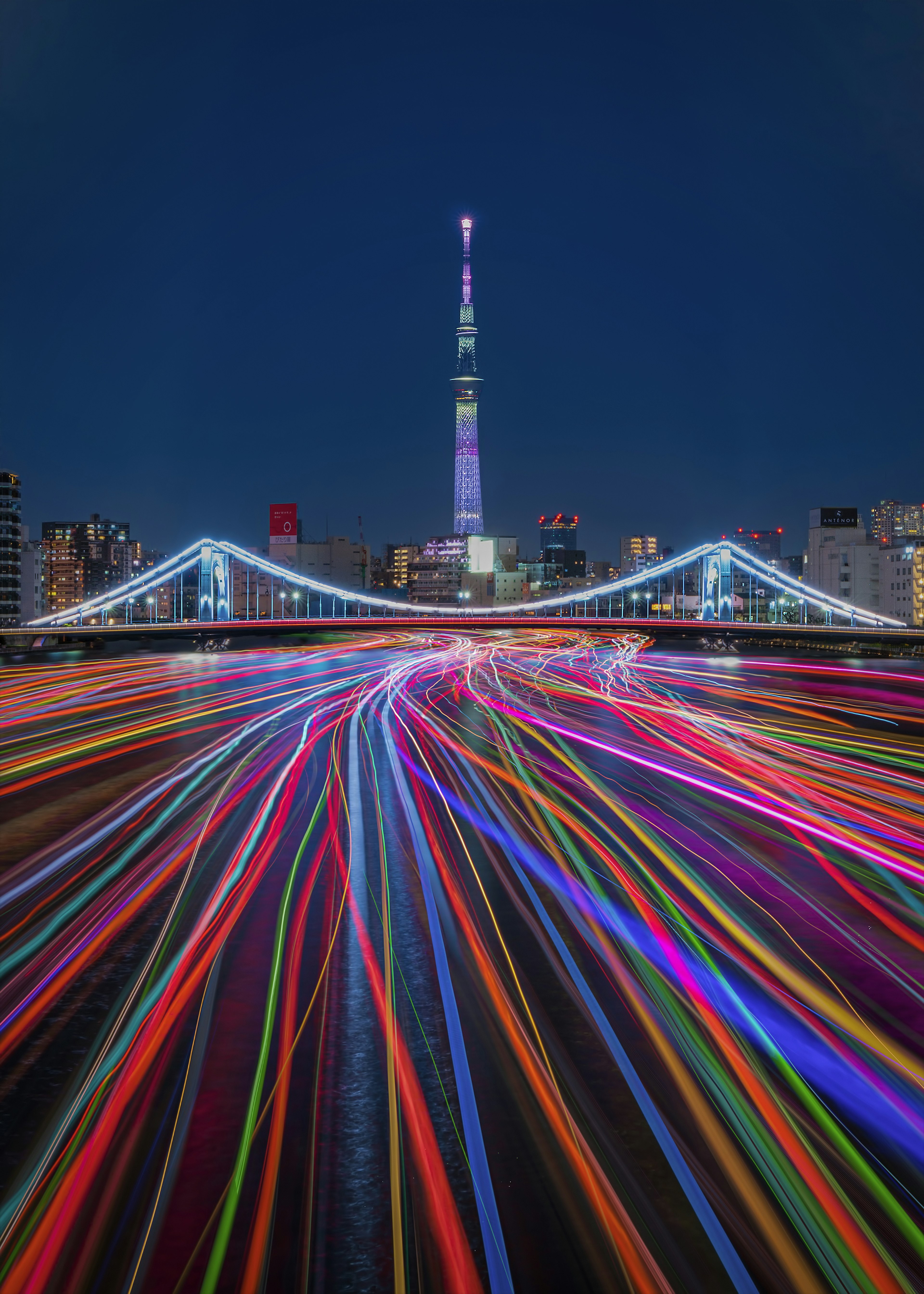 東京スカイツリーとカラフルな光の軌跡が描かれた夜景