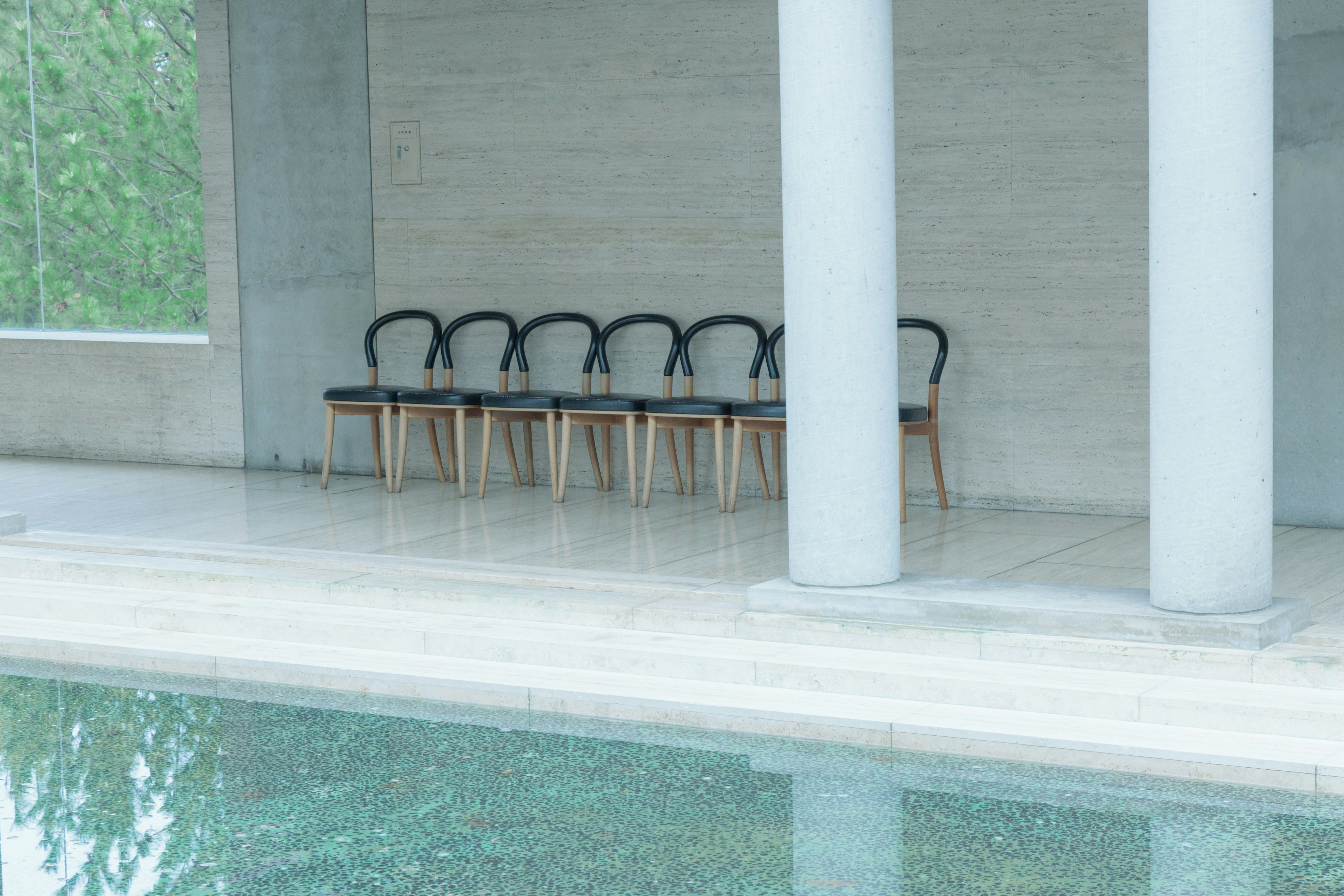 Interno moderno con una fila di sedie a bordo piscina e colonne